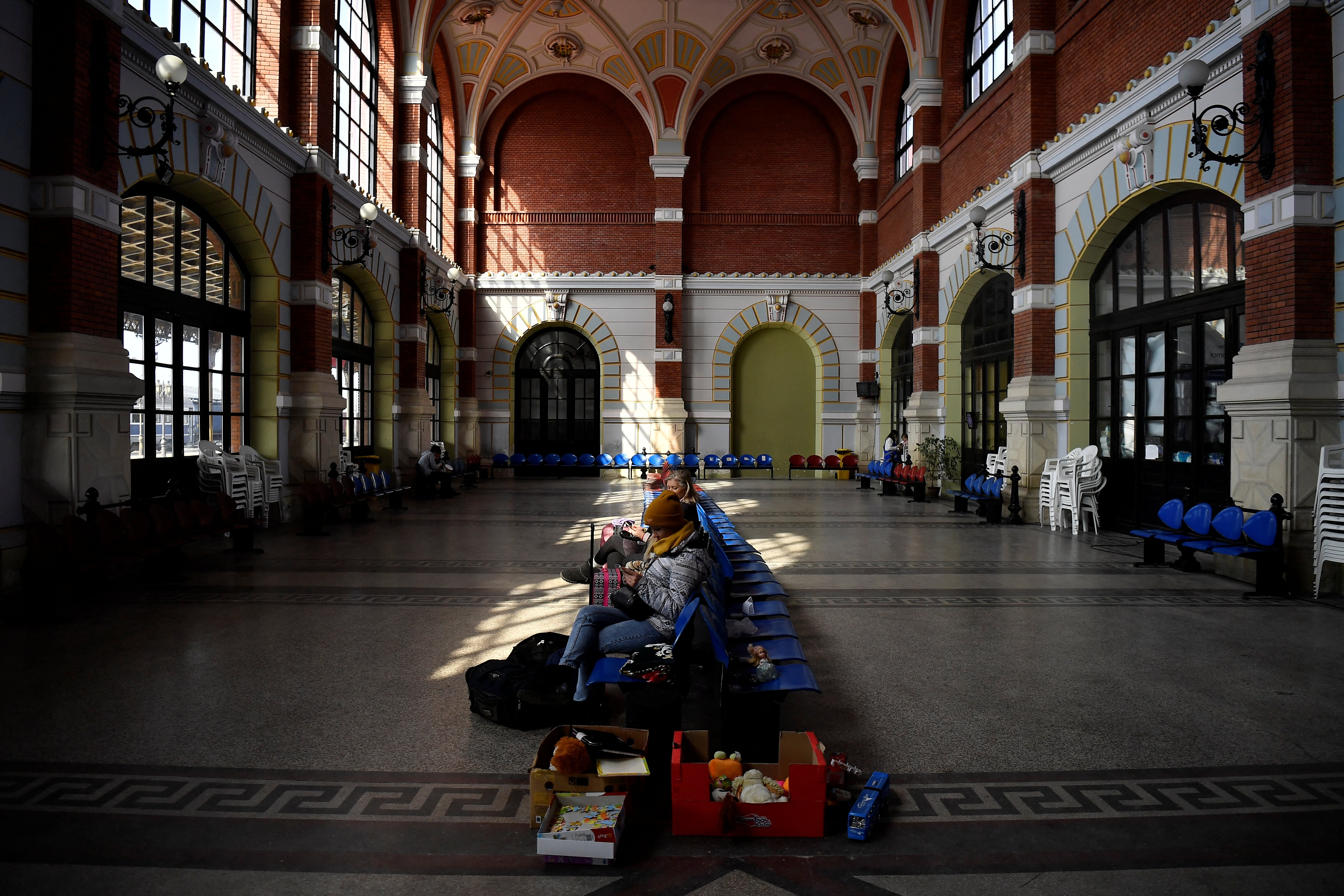 People sit near food which has been left for Ukrainian refugees in the waiting hall at Suceava train station