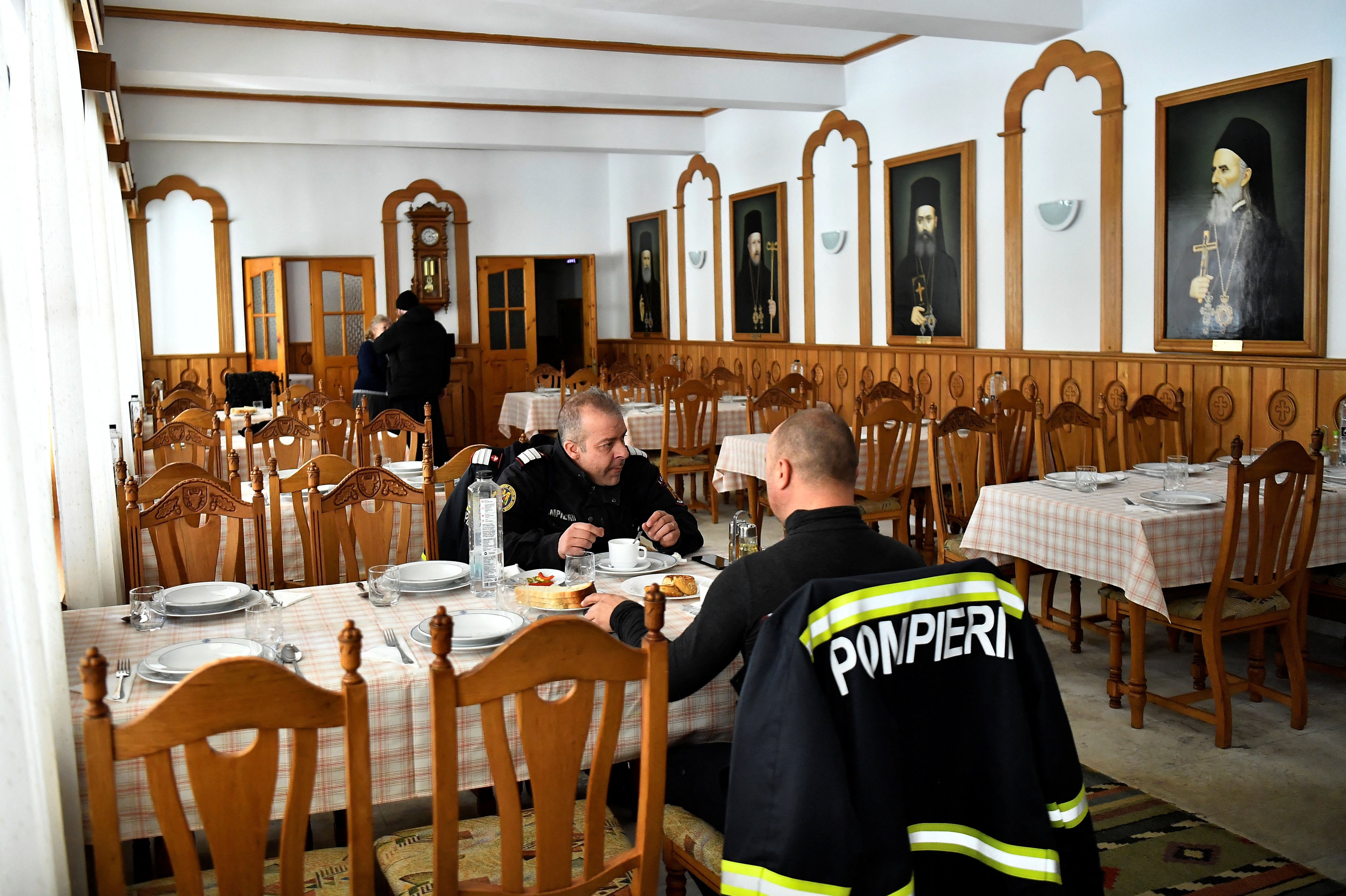 Firefighters eat lunch at the monastery where they are staying while working on the Siret border