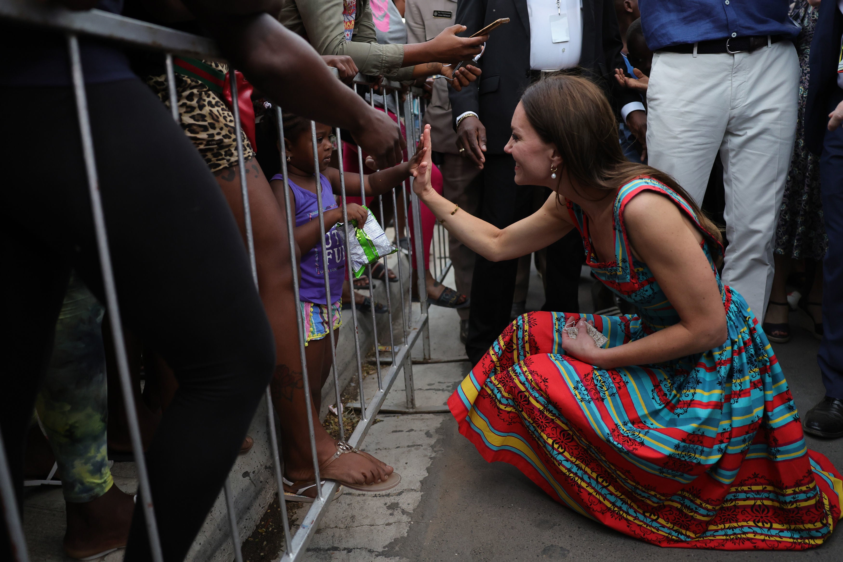 The Duchess of Cambridge high-fives with a child on day four of their tour of the Caribbean