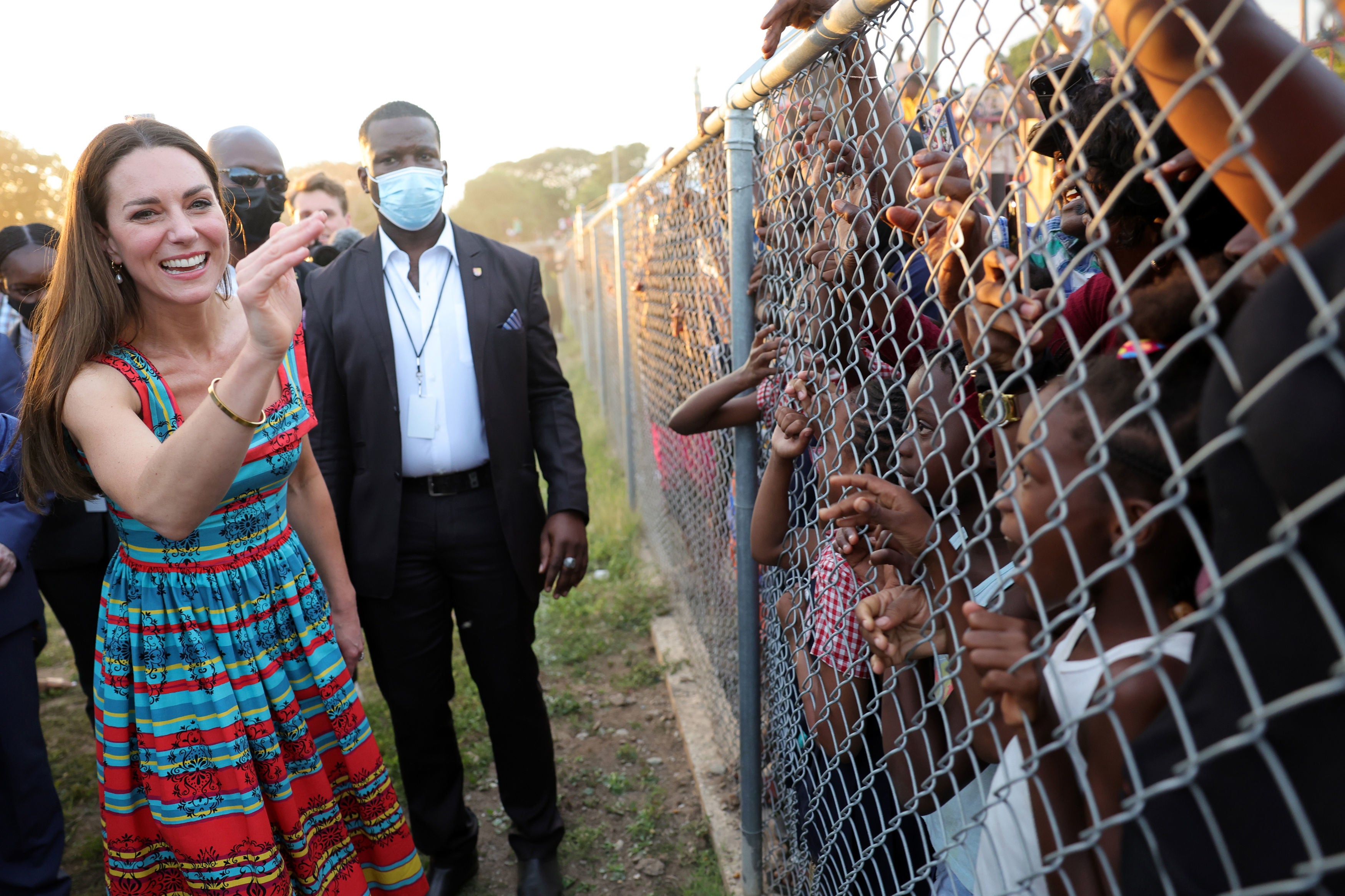 The Duchess of Cambridge waves at children during a visit to Trench Town, the birthplace of reggae in Kingston, Jamaica