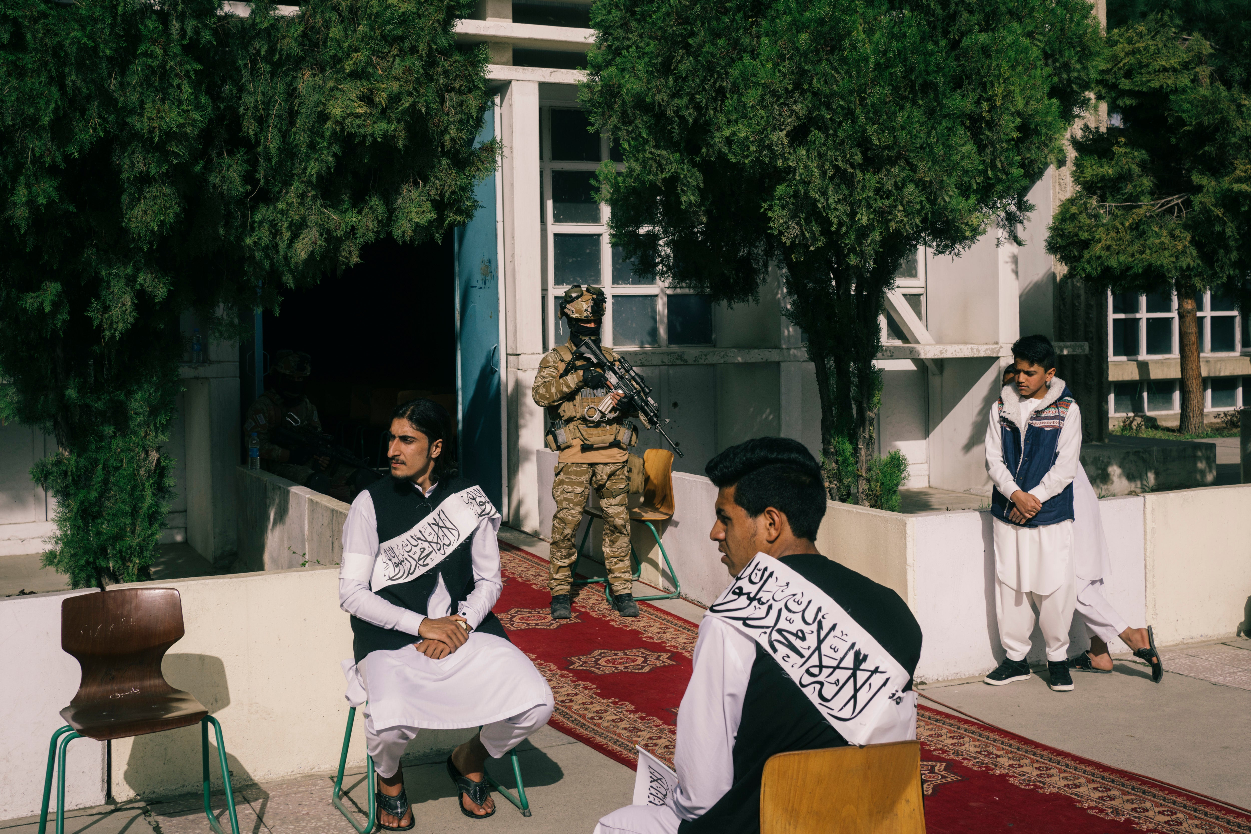 Students and Taliban officials attend a ceremony marking the reopening of schools at the Amani high school in Kabul