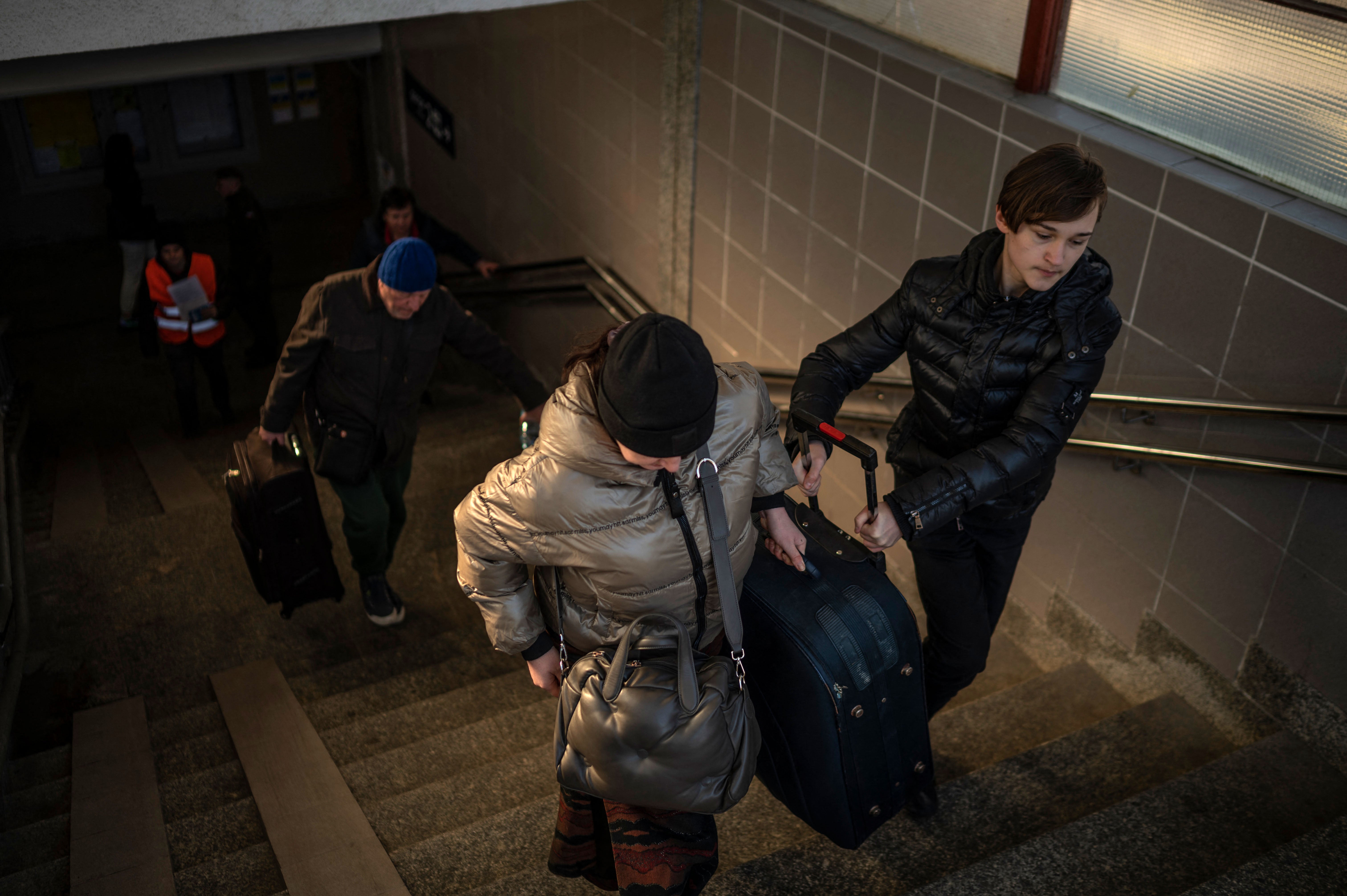 Ukrainian refugees carry their belongings at the railway station in Przemysl, near the Polish-Ukrainian border