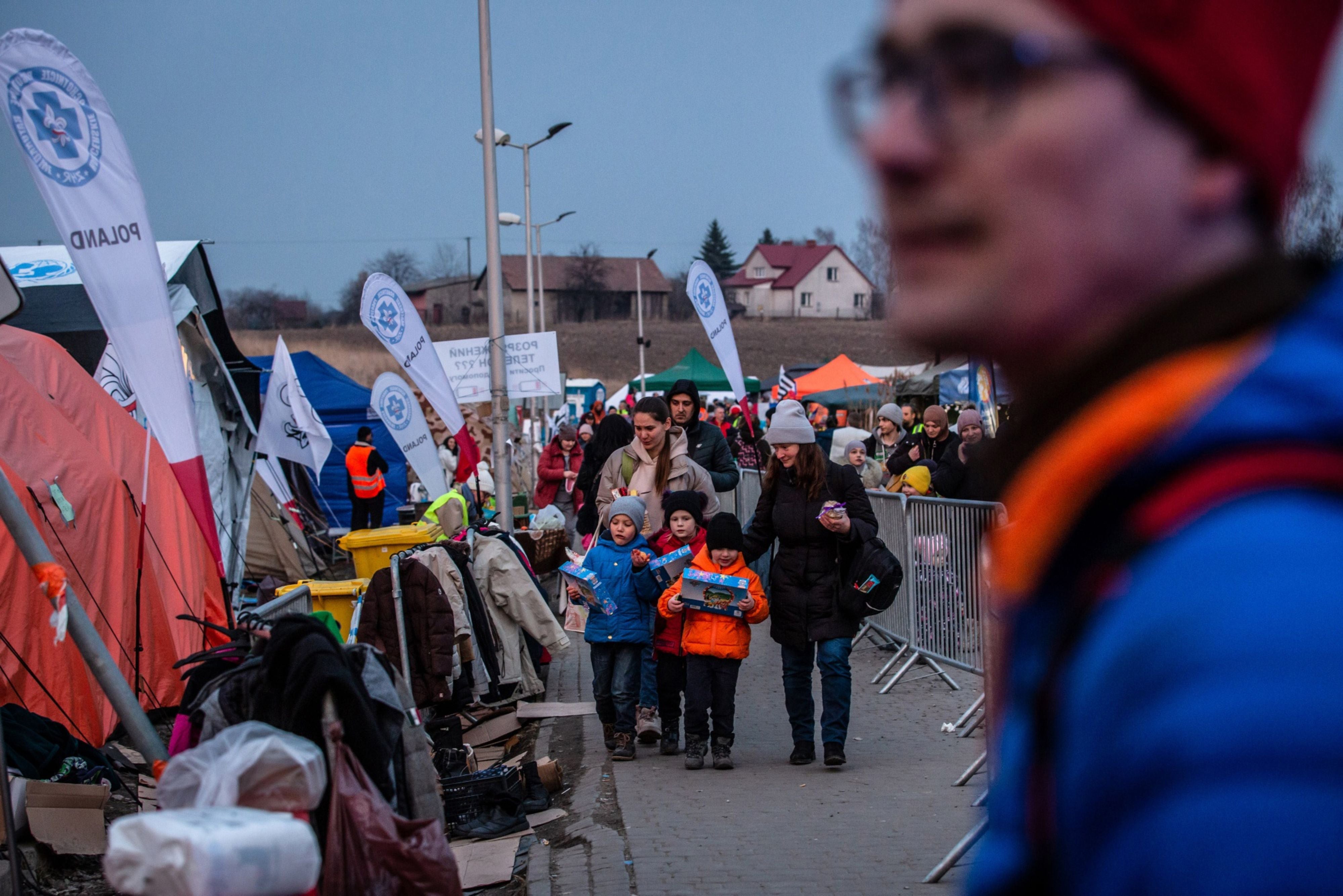 Ukrainian refugee children carry toys taken from an aid point at the Medyka border crossing