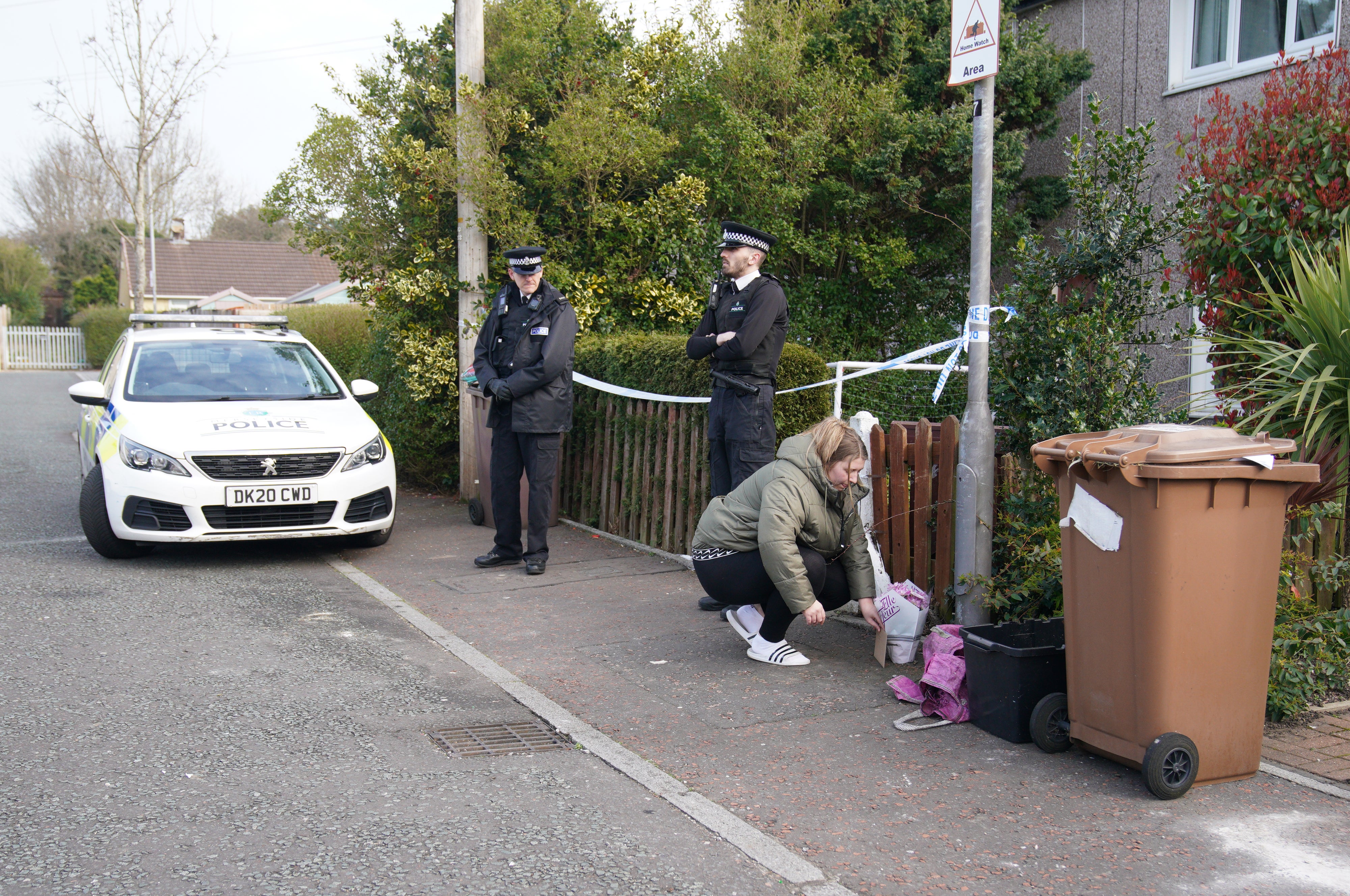 A woman lays flowers outside Bella-Rae’s house in St Helens