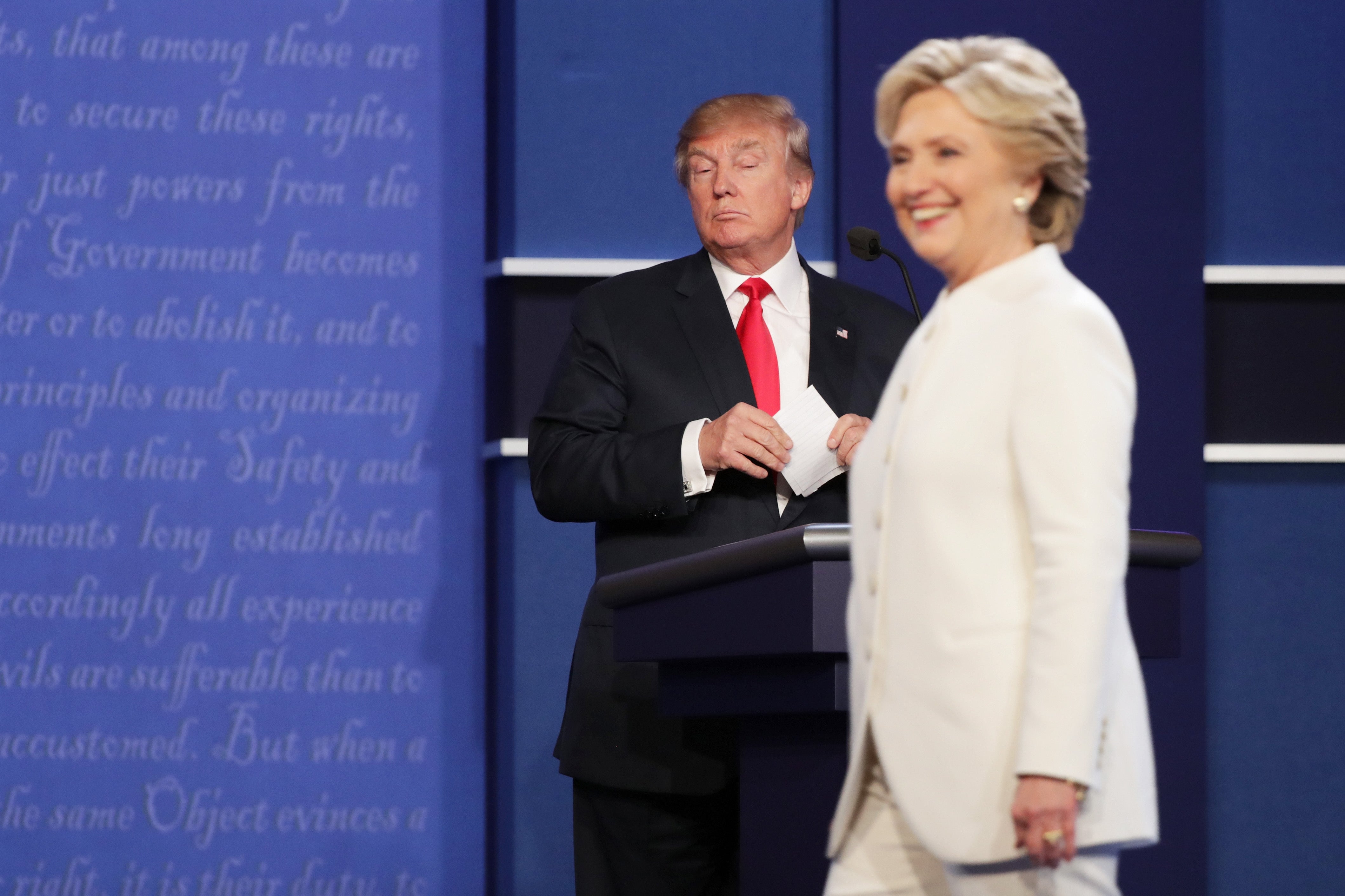 Democratic presidential nominee former Secretary of State Hillary Clinton walks off stage as Republican presidential nominee Donald Trump looks on during the third U.S. presidential debate at the Thomas & Mack Center on October 19, 2016 in Las Vegas, Nevada