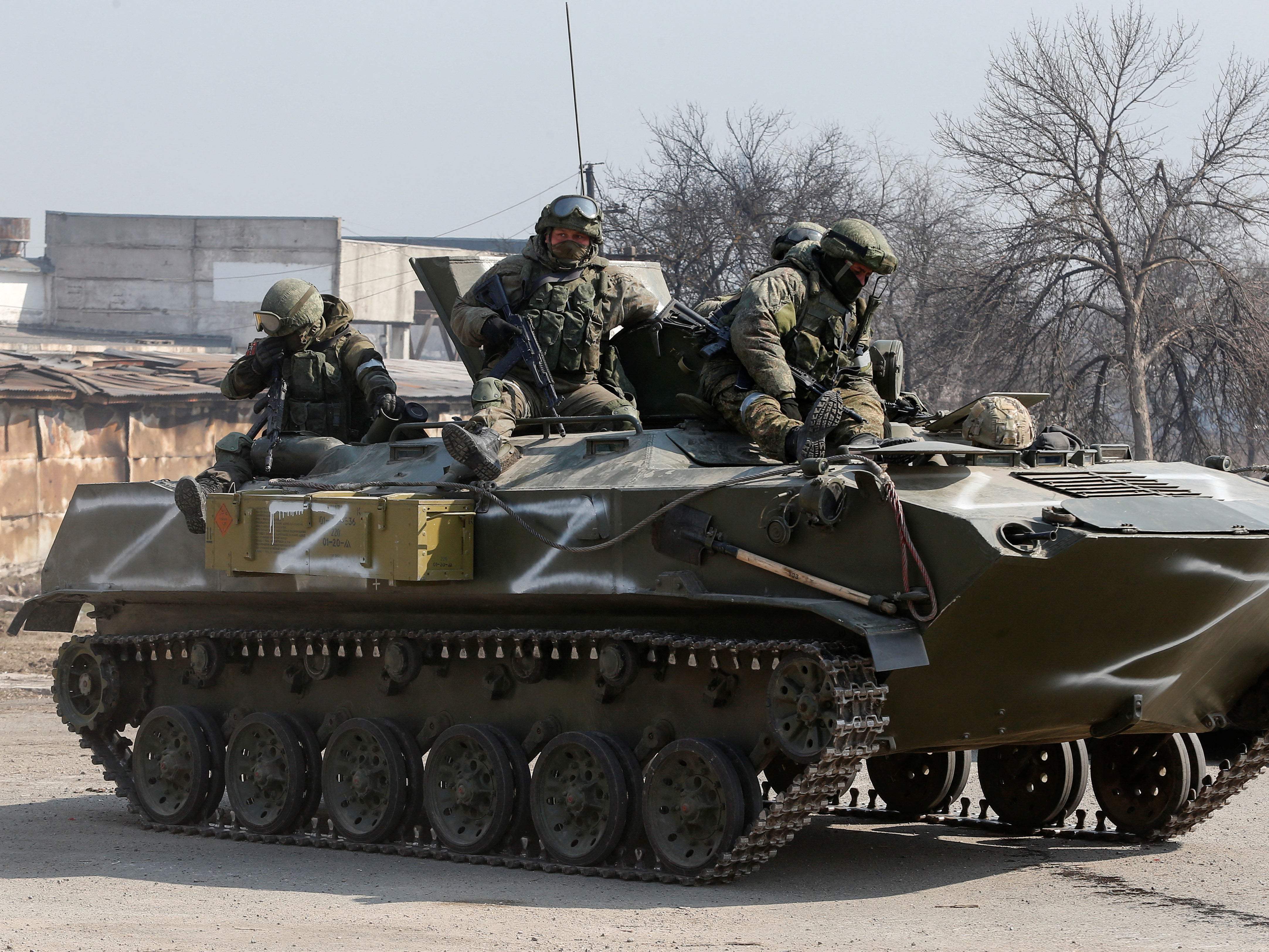 Service members of pro-Russian troops are seen atop an armoured vehicle with ‘Z’ symbols painted on its side in Mariupol