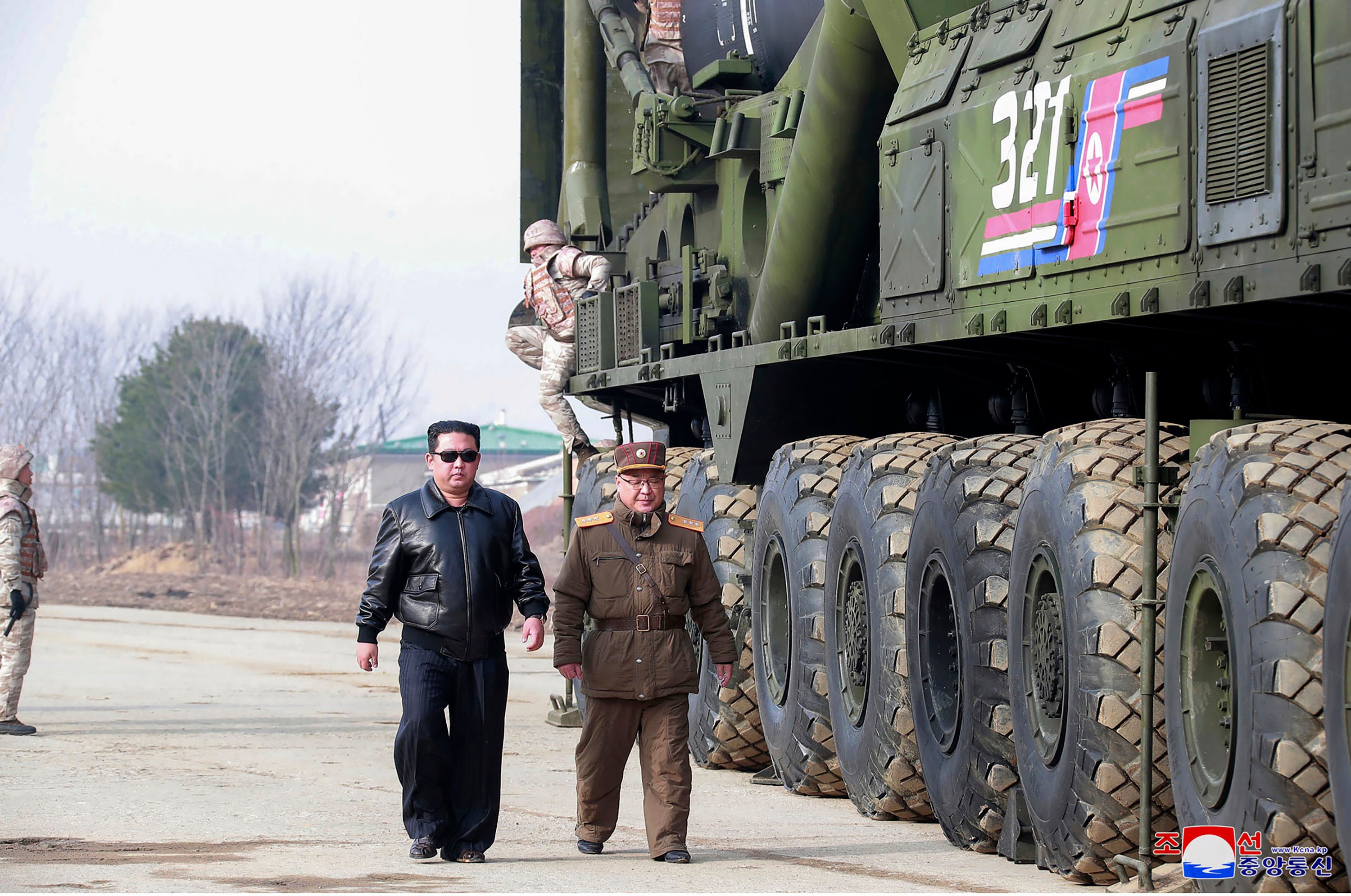 Kim Jong-un, centre left, walks around what it says a Hwasong-17 ICBM on the launcher, at an undisclosed location in North Korea