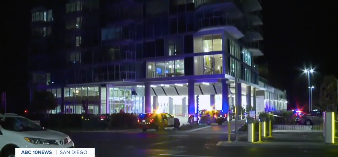 Police at the scene of an apartment complex where a 48-year-old man died attempting to parachute from 23-stories above.