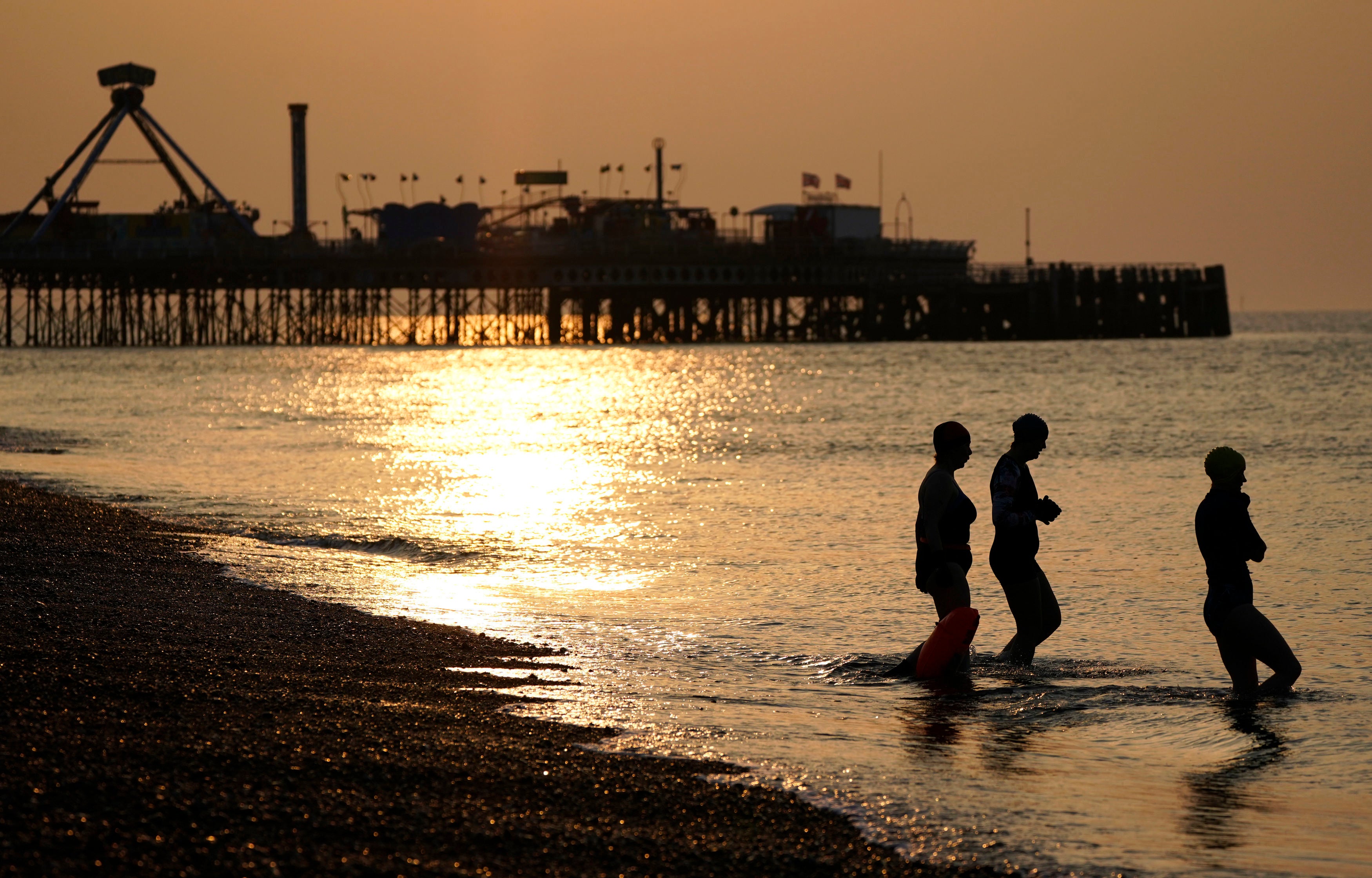 Swimmers make their way into the sea off of Southsea beach in Hampshire