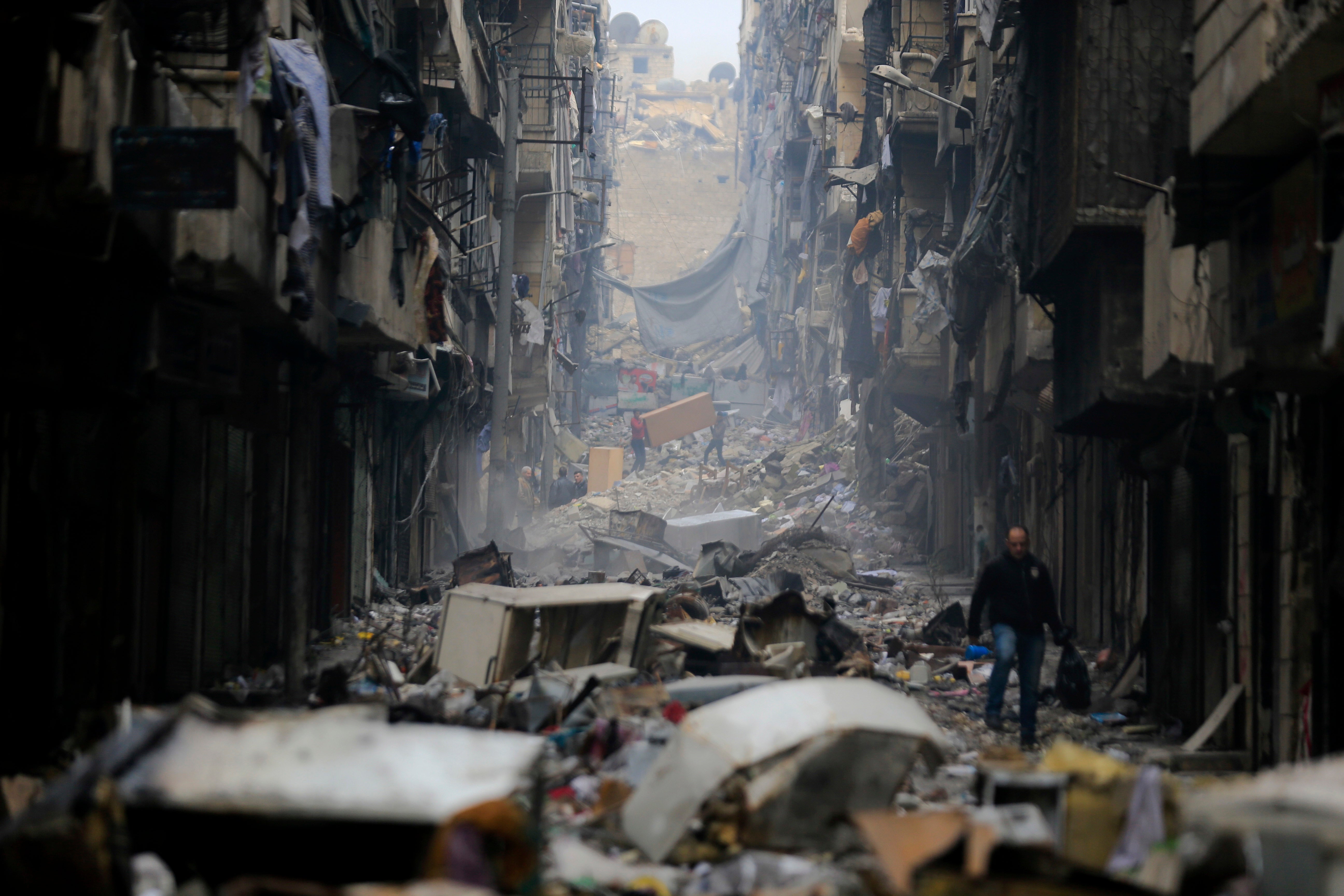 Residents walk through the destruction of the once rebel-held Salaheddine neighborhood in eastern Aleppo in 2017