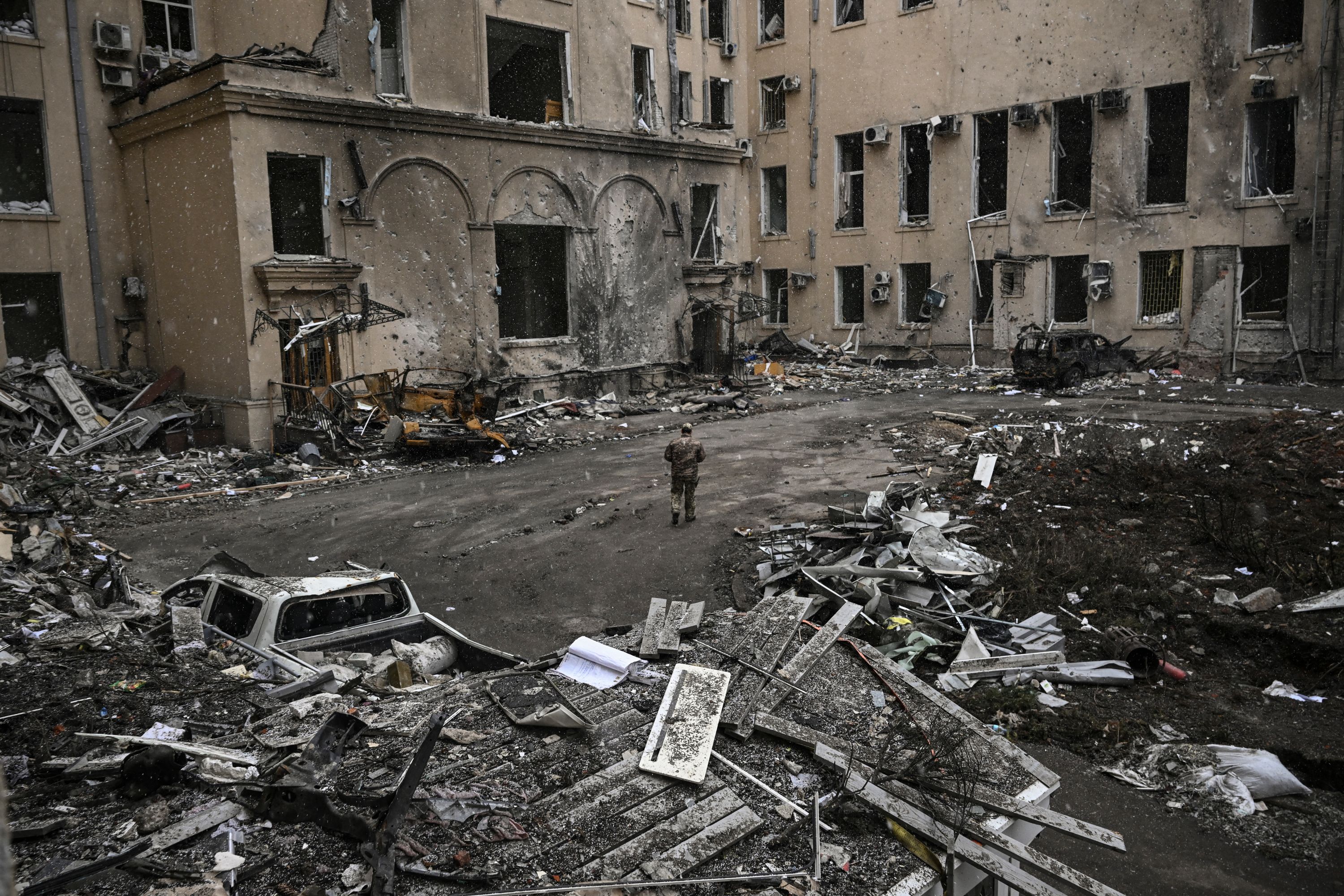 A Ukrainian soldier walks beside rubble in Kharkiv, Ukraine, on 27 March 2022