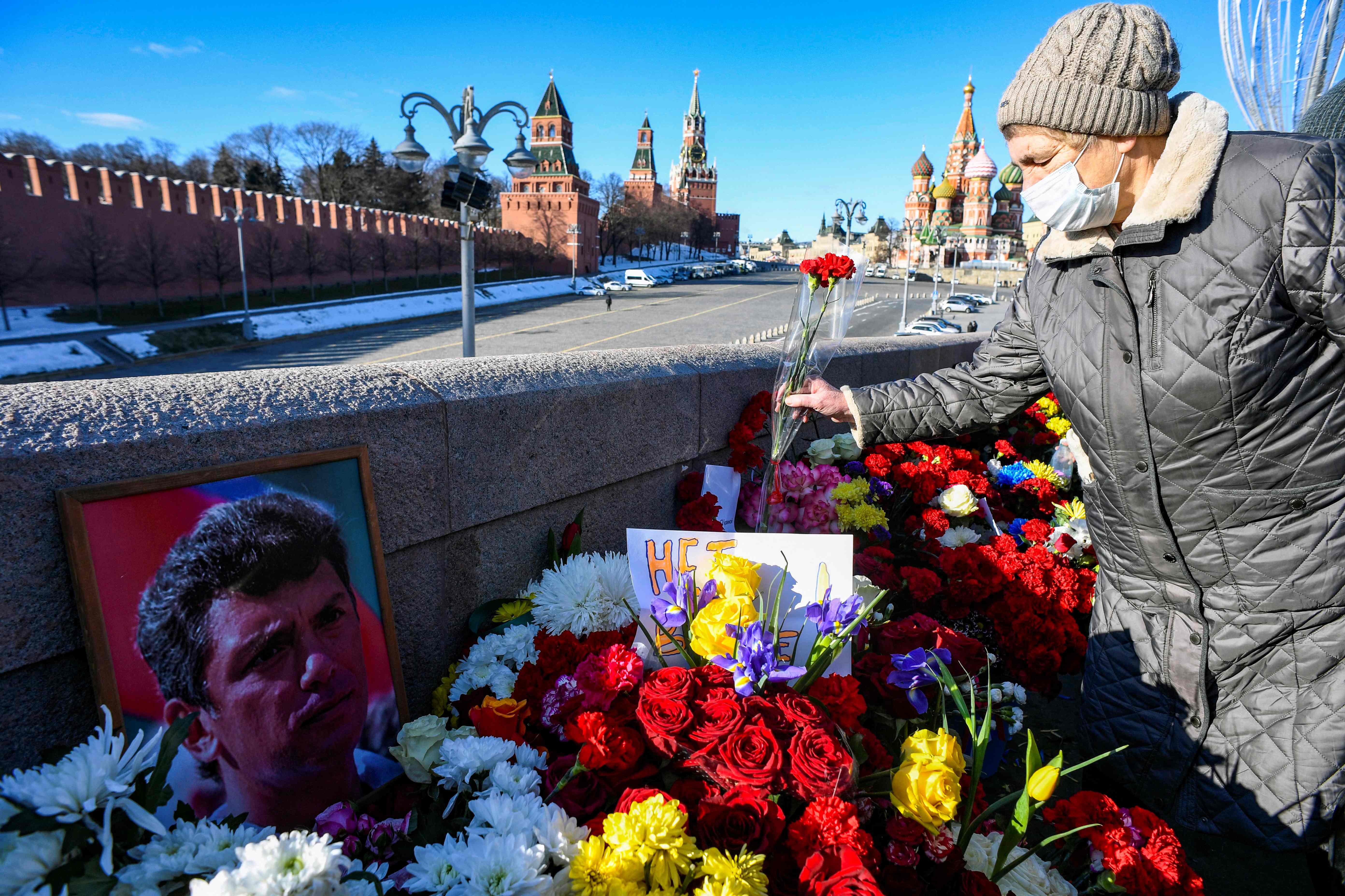 People lay flowers at the site where late opposition leader Boris Nemtsov was fatally shot on a bridge near the Kremlin in central Moscow on February