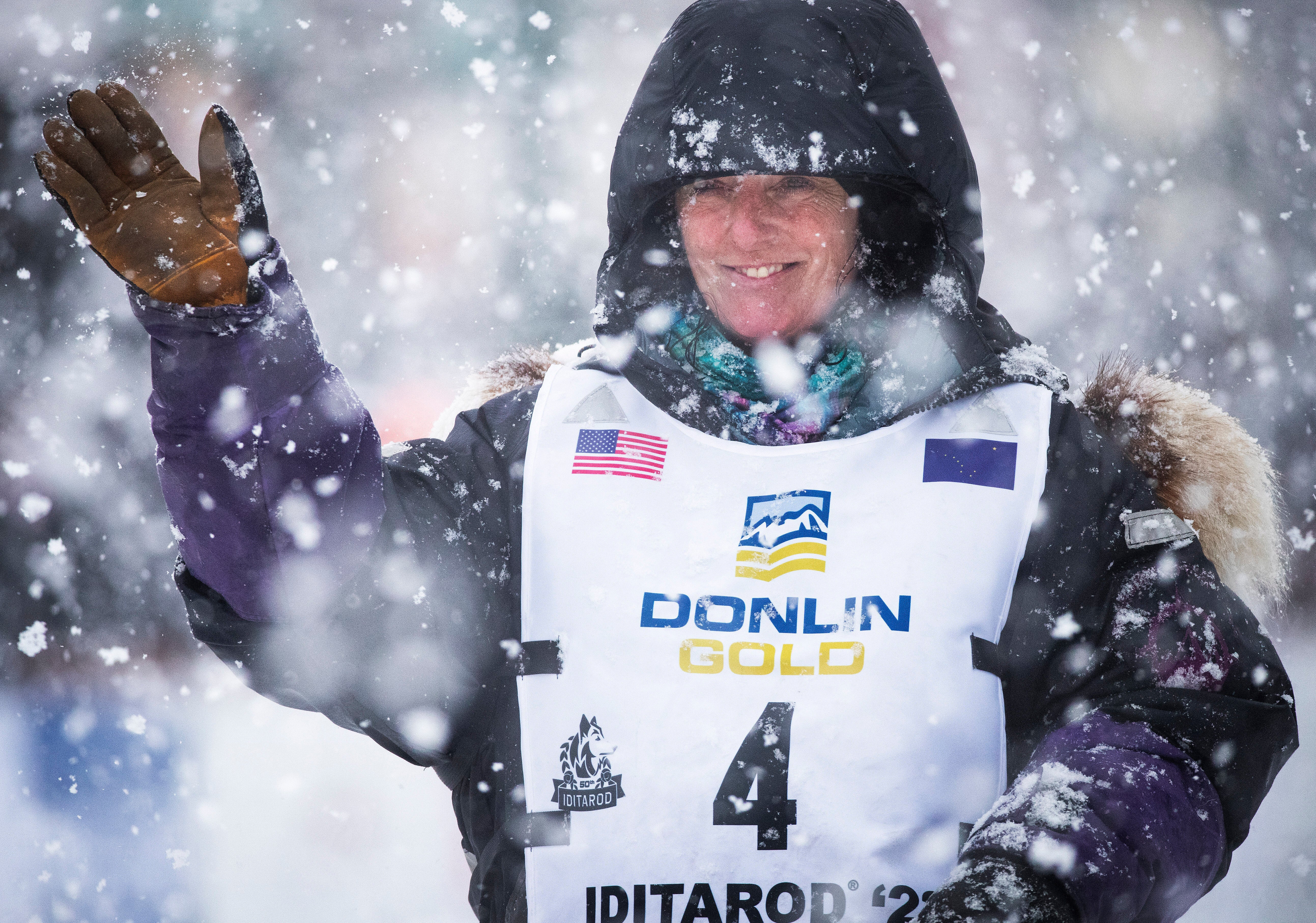 Canadian musher Michelle Phillips waves to the crowd as she takes off down Fourth Street during the ceremonial start of the Iditarod Trail Sled Dog Race in Anchorage, Alaska, March 5, 2022