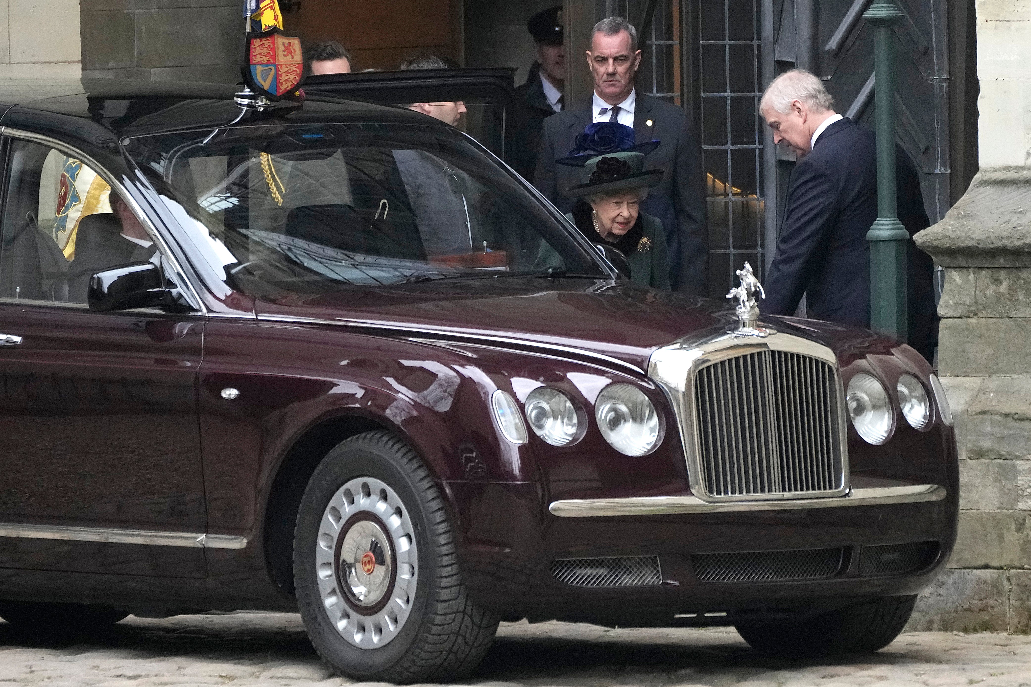 Queen Elizabeth II is helped into her car by her son Prince Andrew, right, after attending a Service of Thanksgiving for the life of Prince Philip