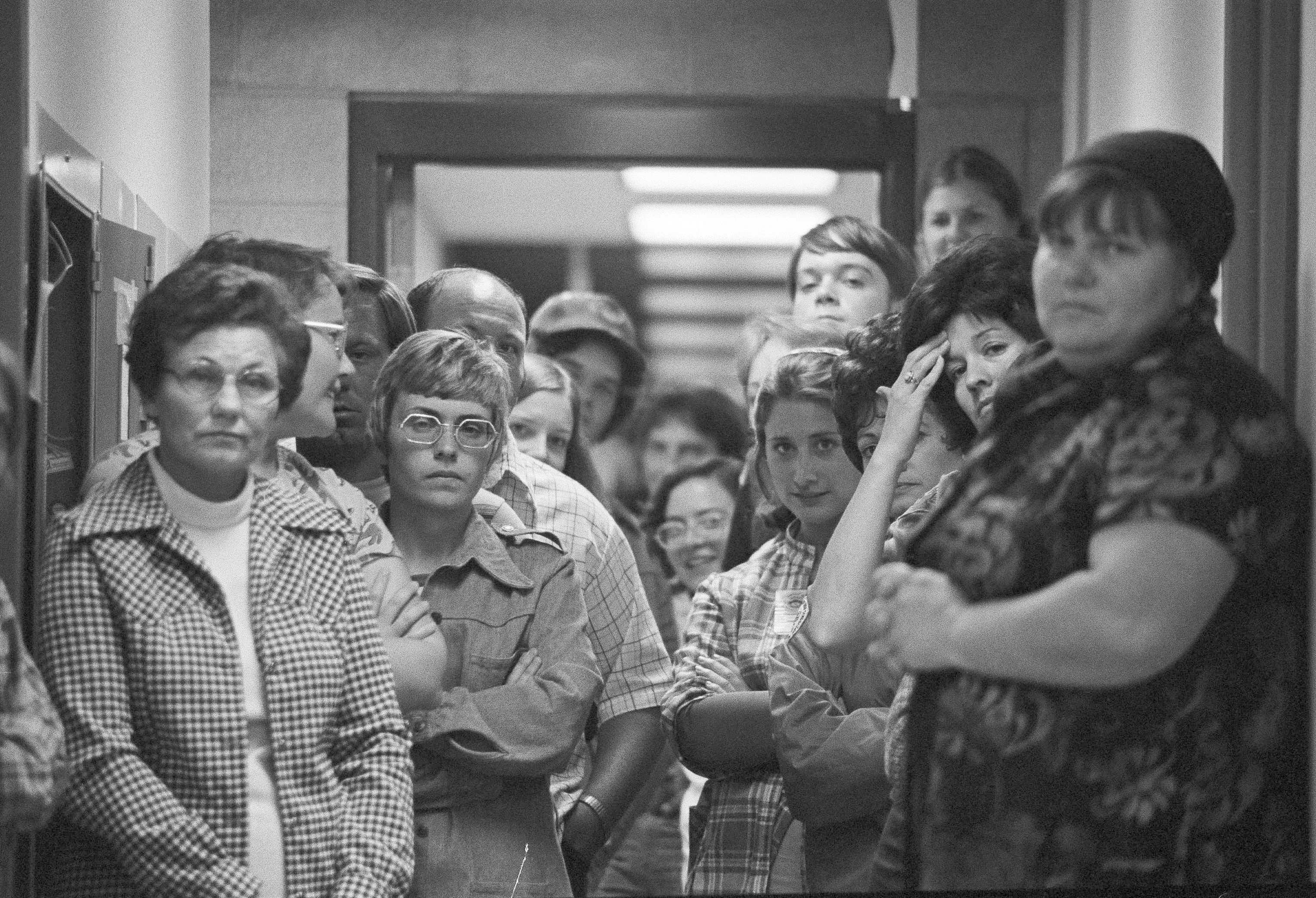 Families of the Dairyland Union School District children and their bus driver wait anxiously inside the Chowchilla police station as the students unload from the chartered bus that returned them the site where they were found