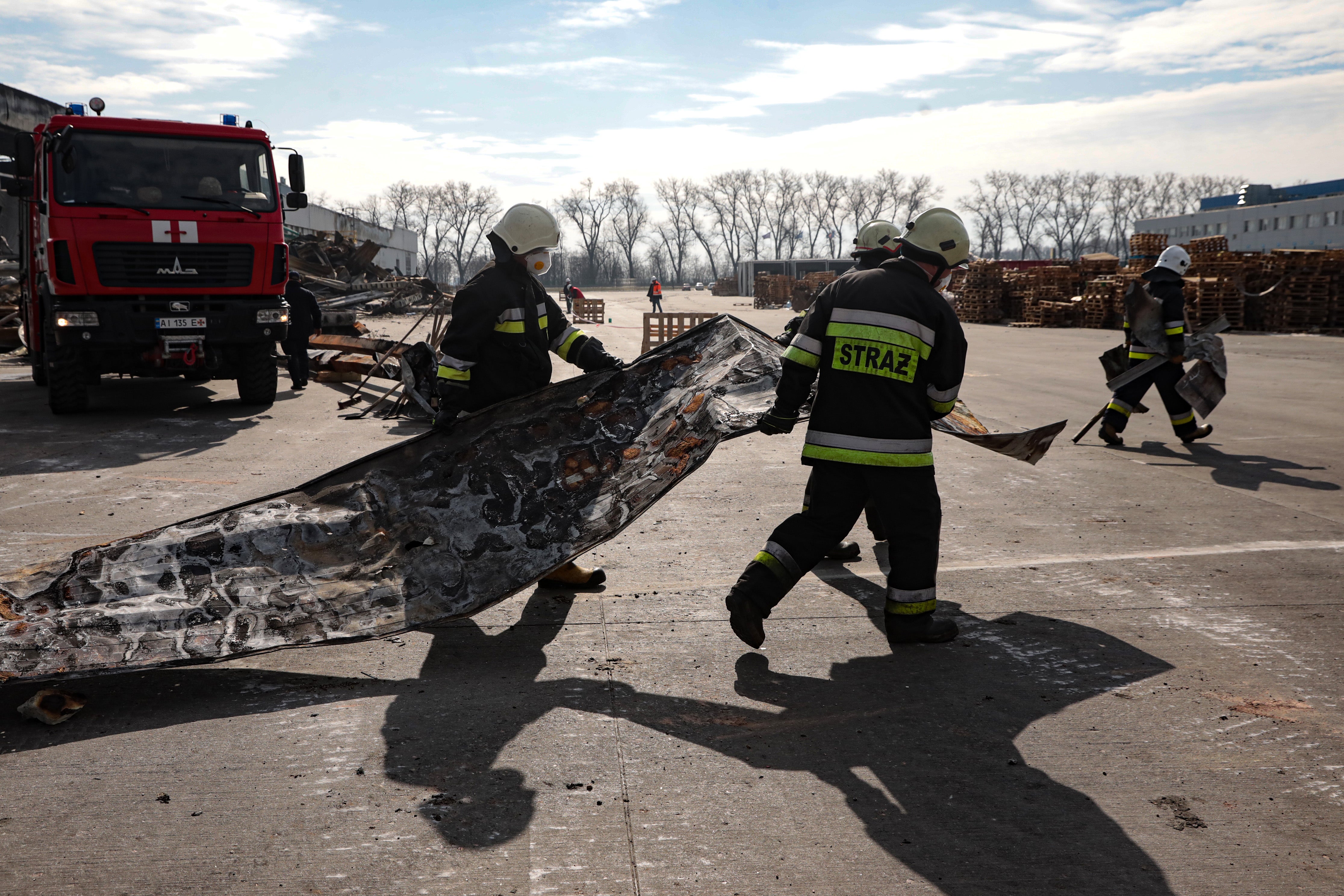 Rescuers clear debris after the Russian shelling of a food warehouse in Brovary, Kyiv