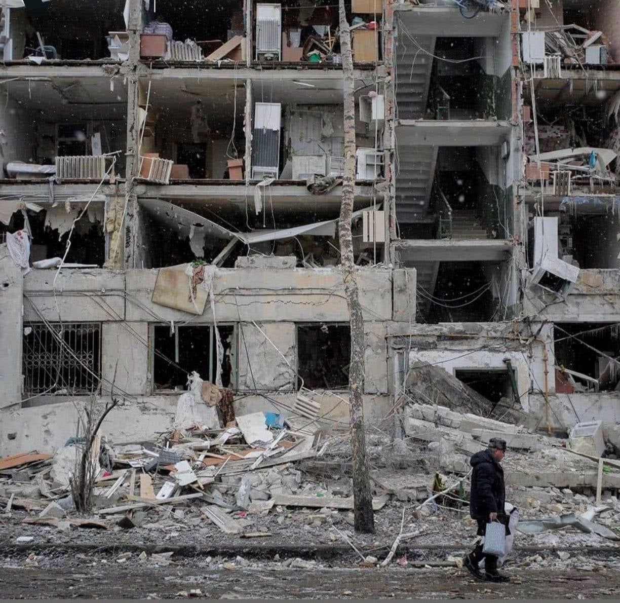 A resident walks passed a damaged building in Kharkiv