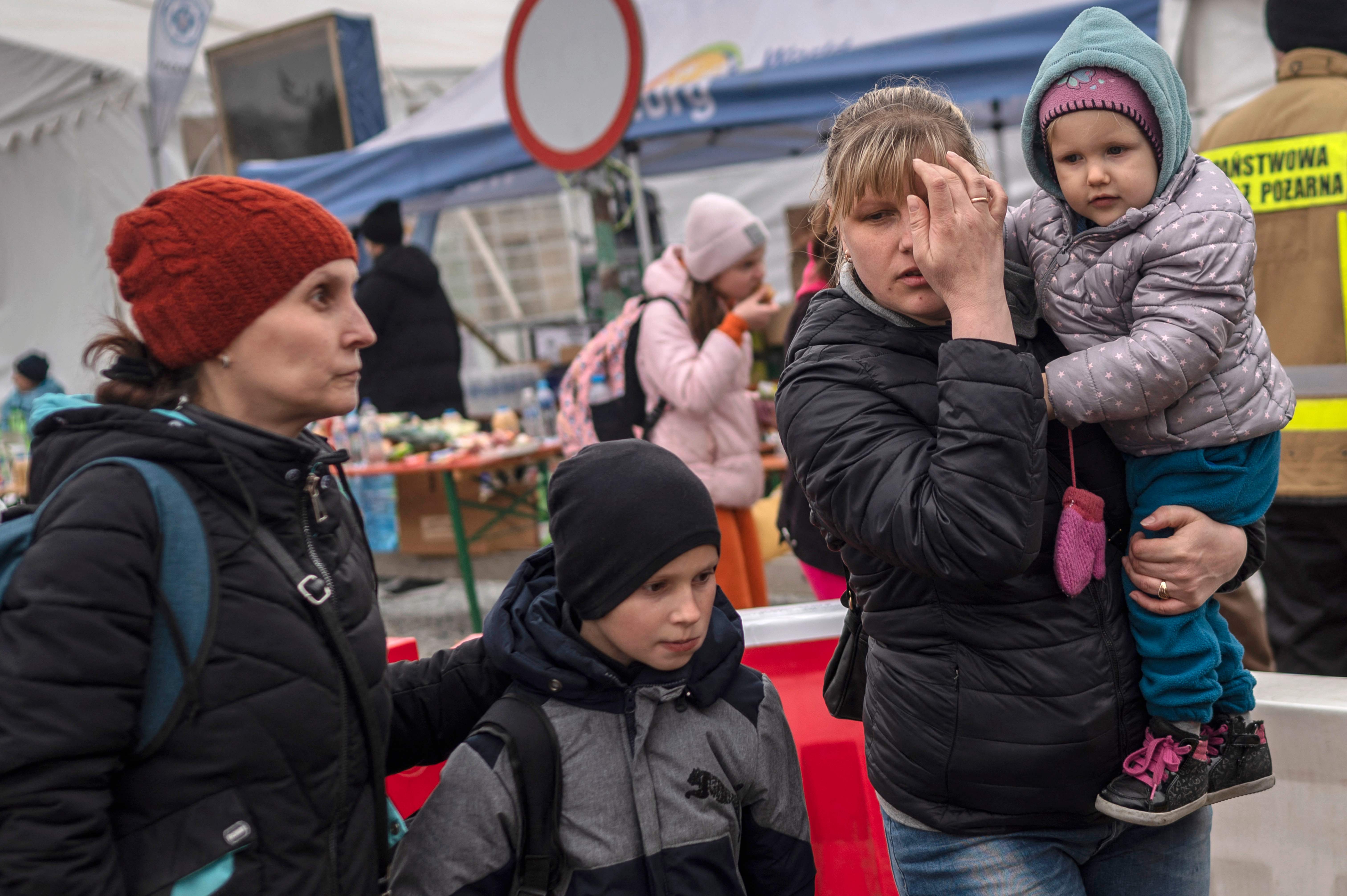 Ukrainian evacuees queue as they wait for further transport at the Medyka border crossing, after they crossed the Ukrainian-Polish border on Tuesday