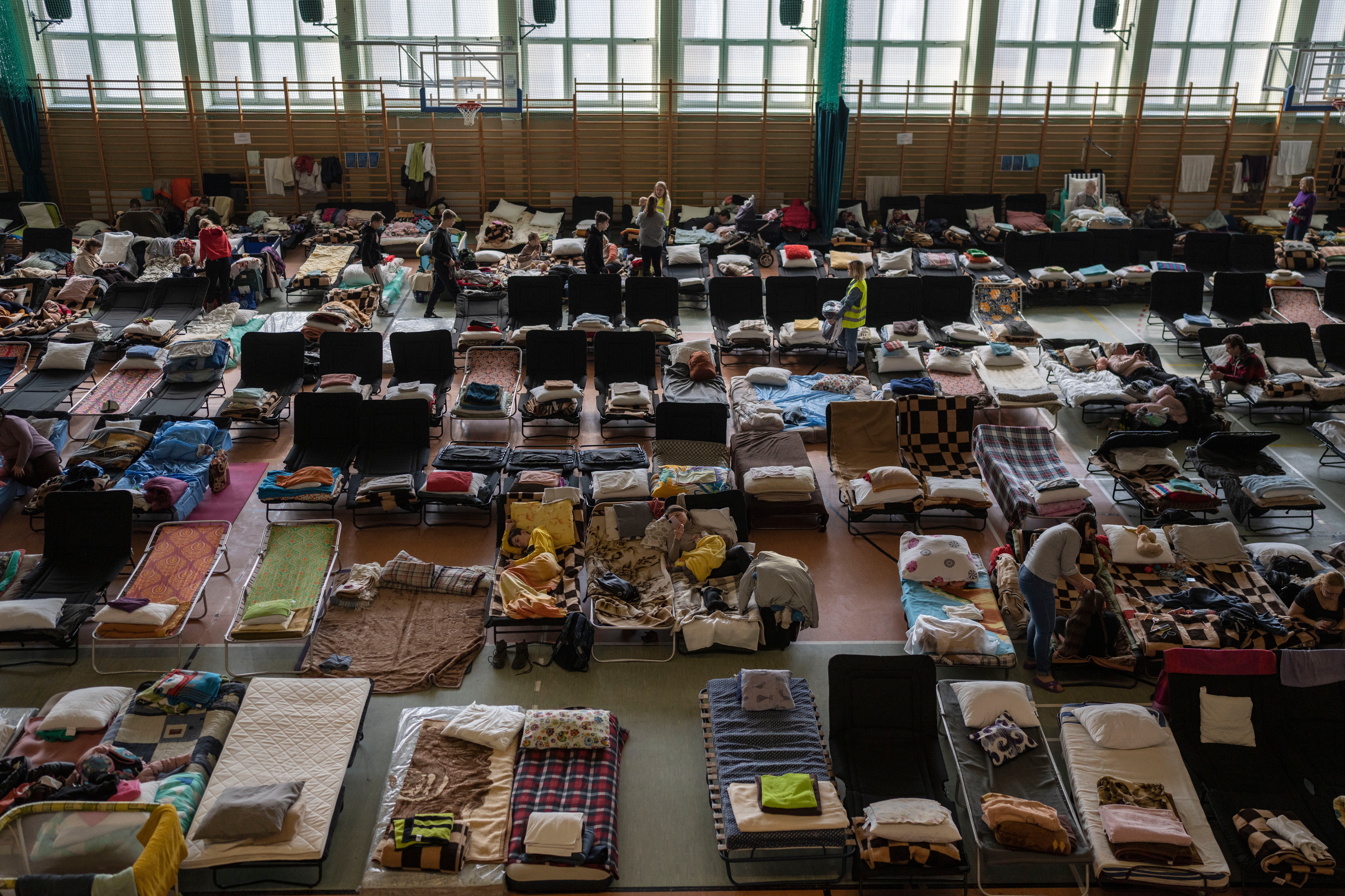 People who fled the war in Ukraine rest inside an indoor sports stadium being used as a refugee centre in the Polish village of Medyka