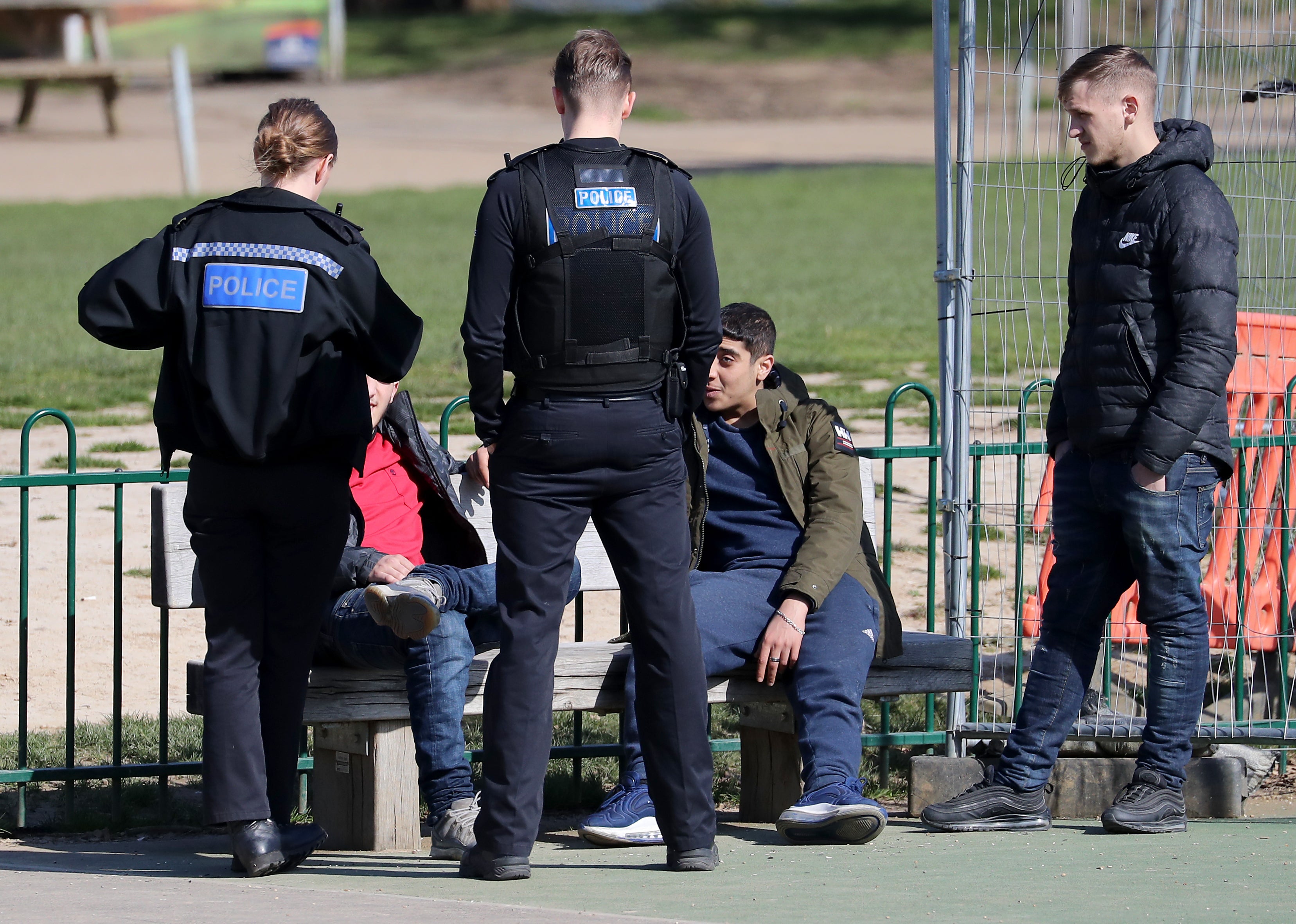 A group of young men are spoken to by Kent Police officers before being dispersed from a children's play area in Mote Park, Maidstone, the day after Prime Minister Boris Johnson put the UK in lockdown to help curb the spread of the coronavirus