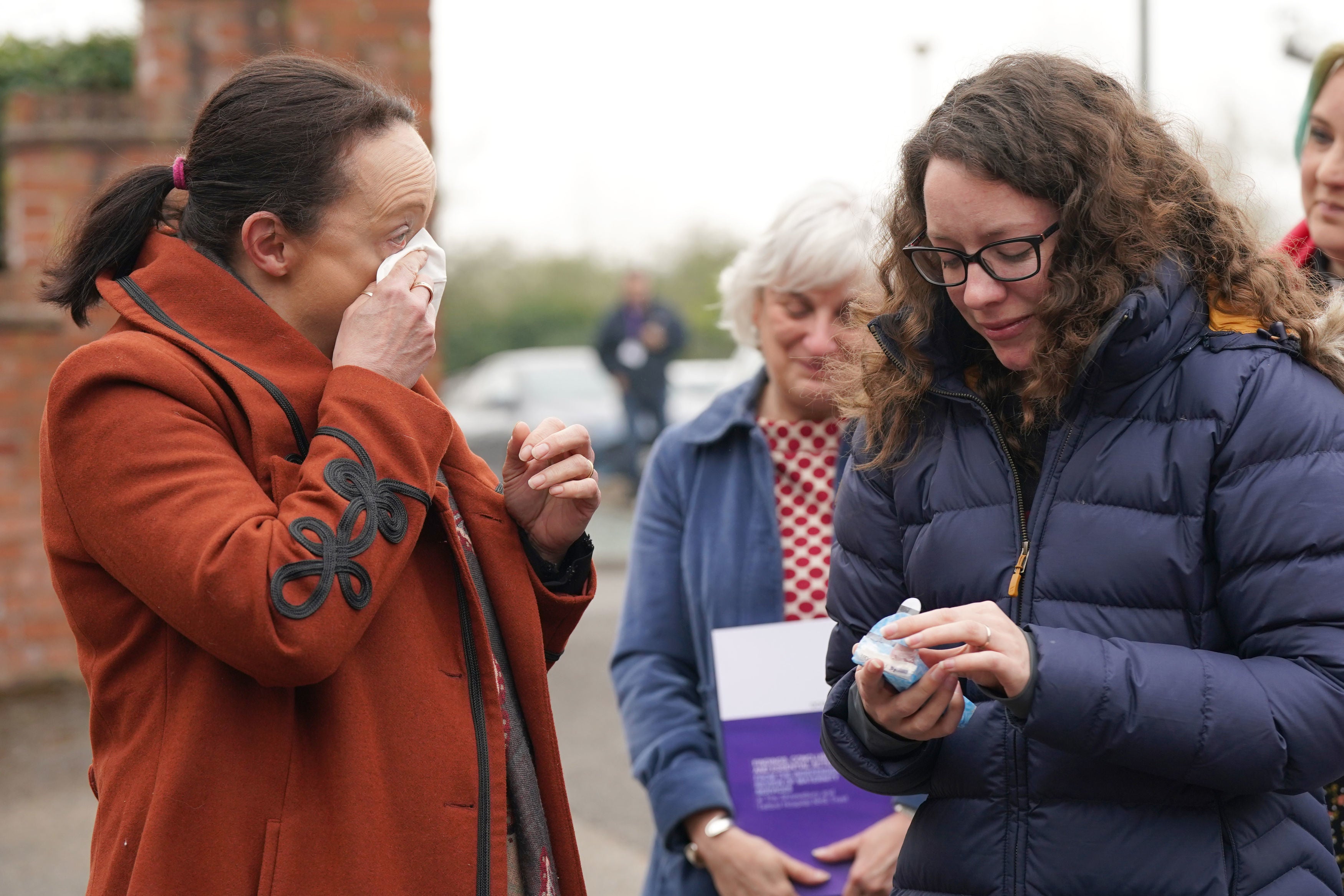 Rhiannon Davies (left) and Kayleigh Griffiths (right) react following the release of the final report