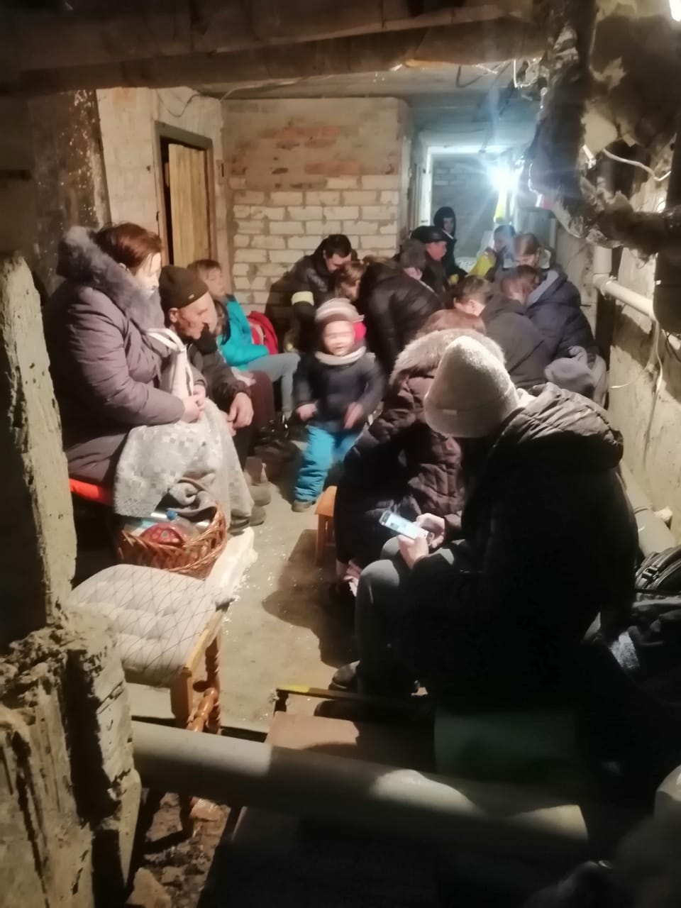 Yulia Zhdanova’s family and neighbours taking shelter in their basement during air raids in Chernihiv