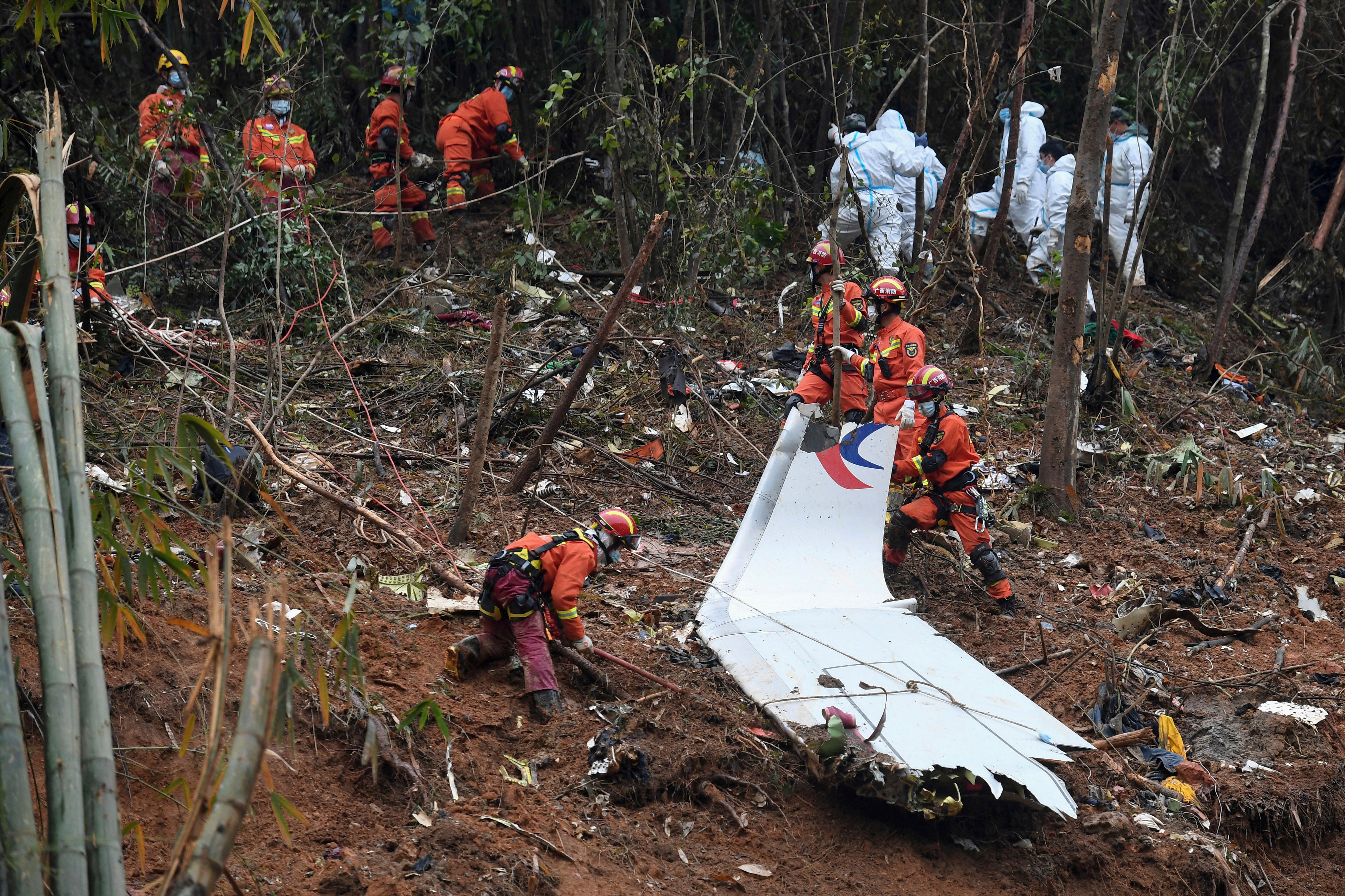 Rescue workers search through debris at the China Eastern flight crash site in Tengxian County