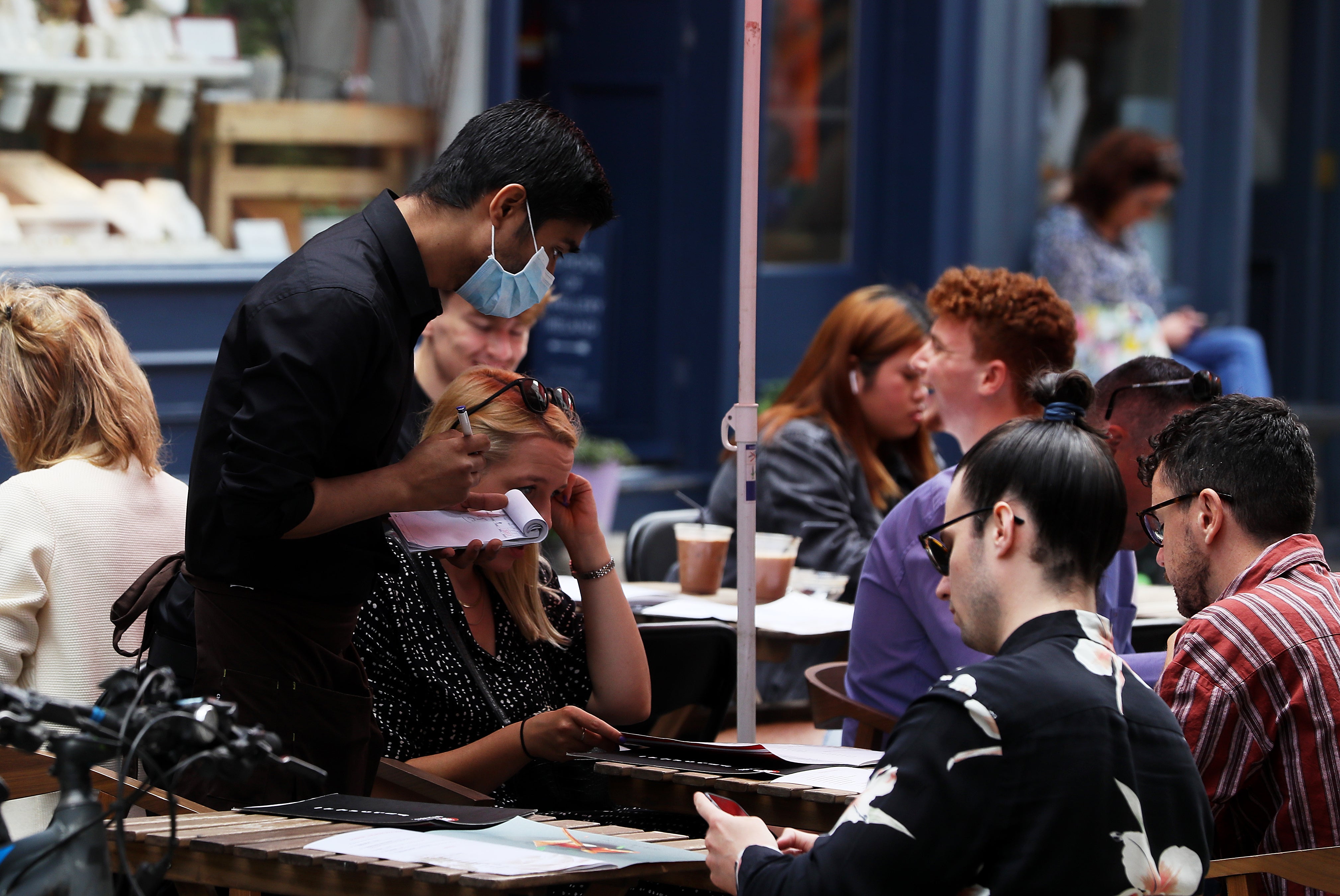 A waiter takes orders at a restaurant. VAT on food is set to increase among a raft of tax changes coming into force in April (Brian Lawless/PA)