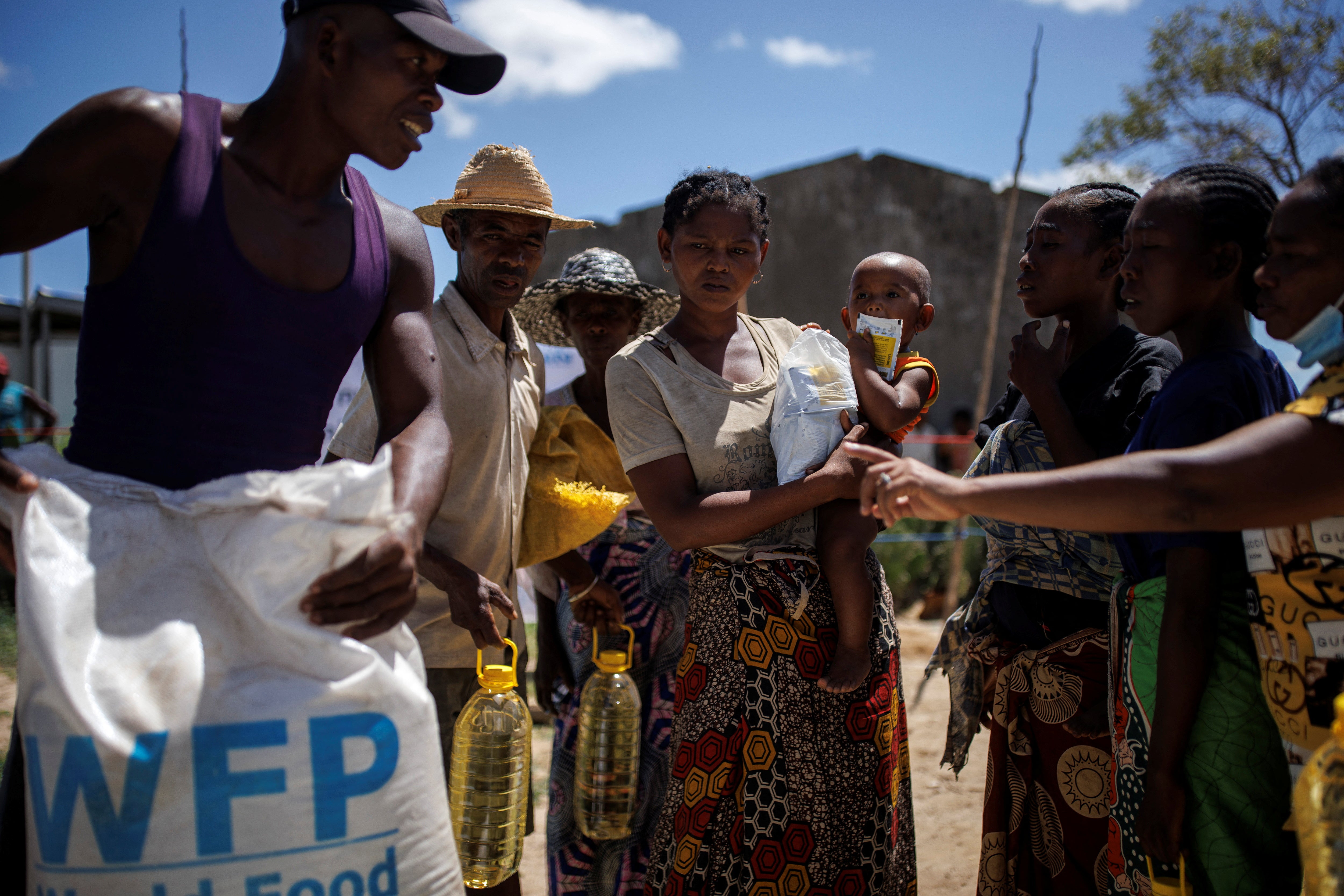 Masy Modestine holds her son Lahimaro, two, while waiting to receive goods at a food distribution post