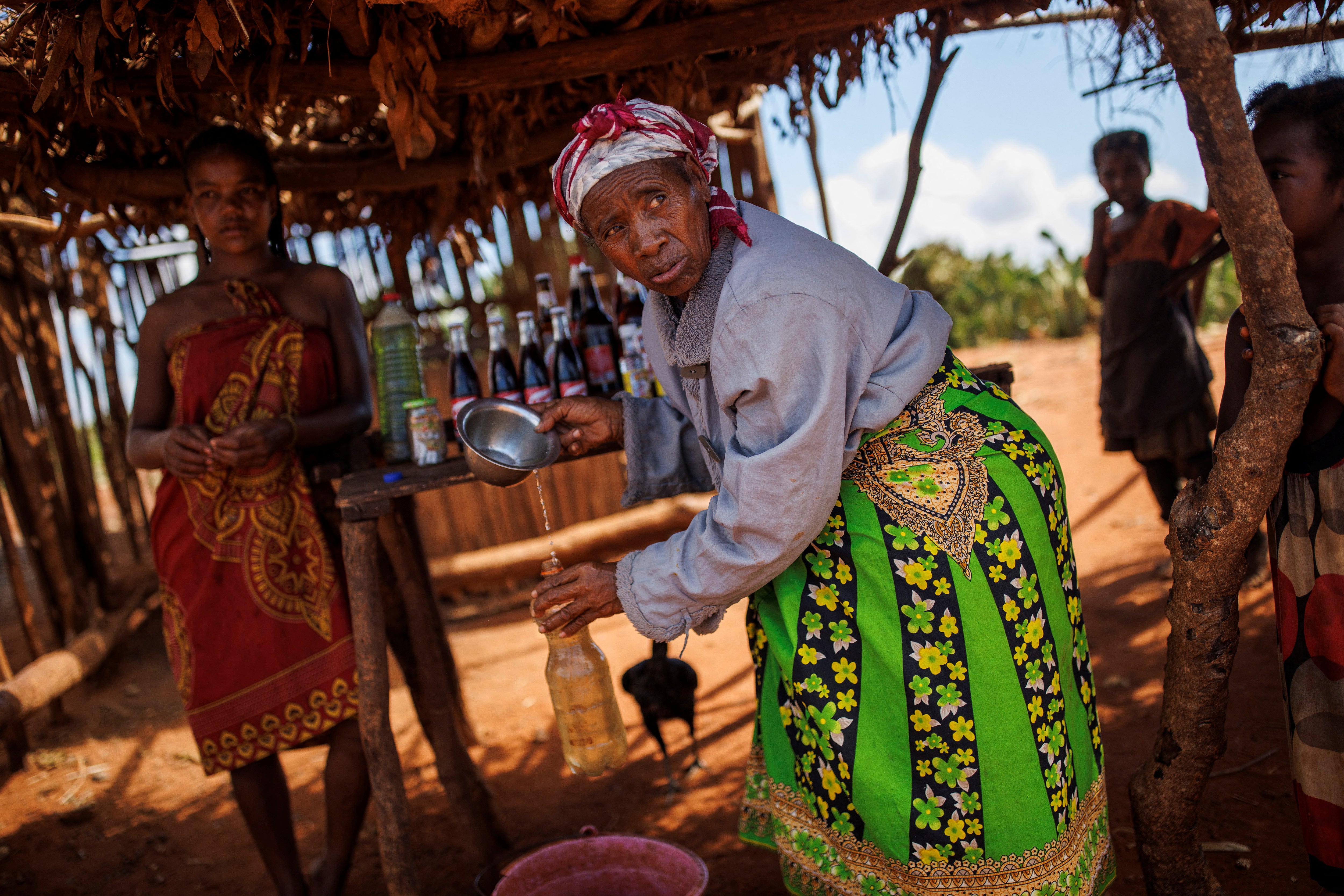 A woman fills a plastic canister with water at a road stop in the Sampona commune, Anosy region