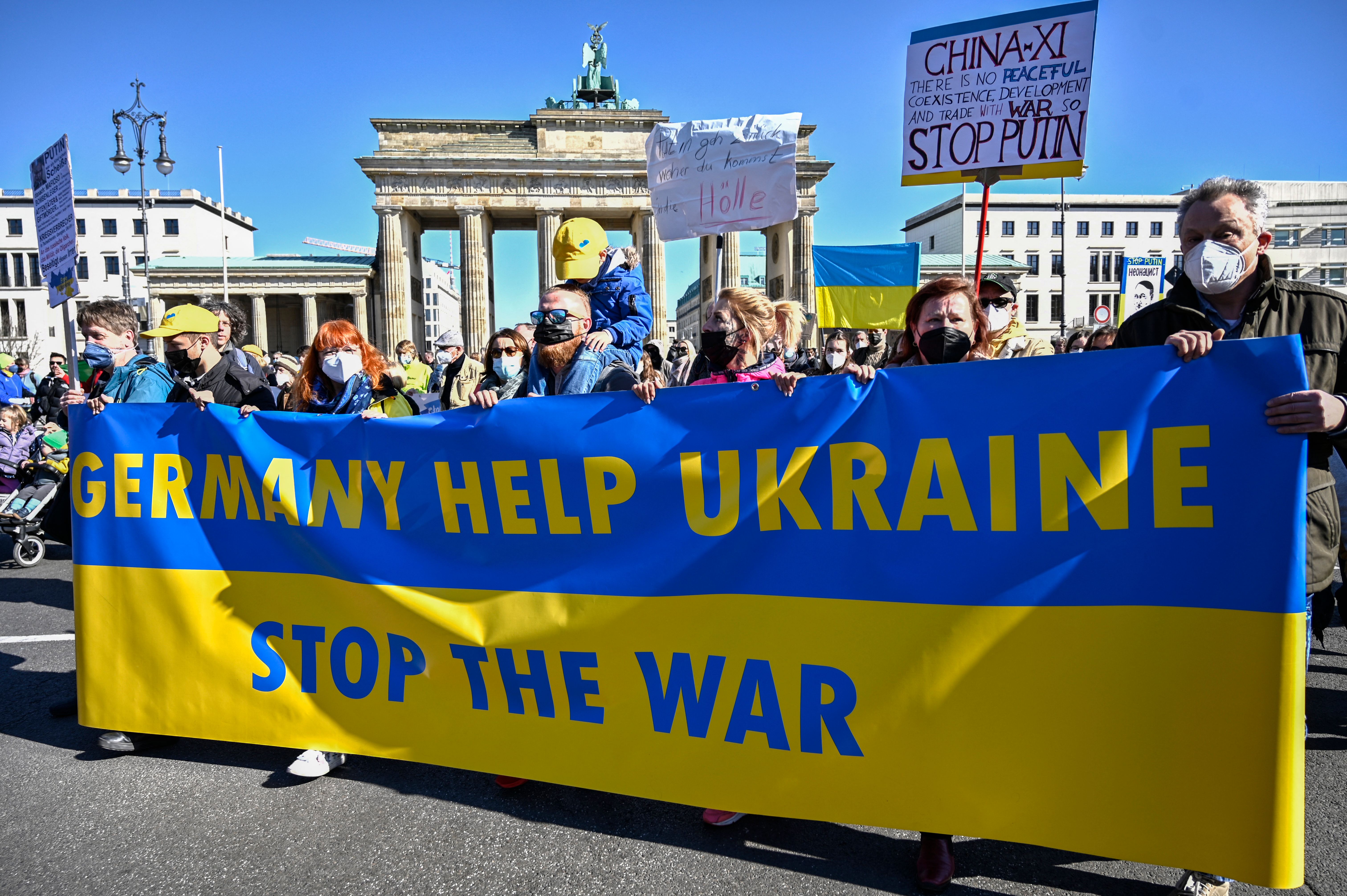 Protesters hold up a banner during a demonstration in Berlin, 13 March 2022