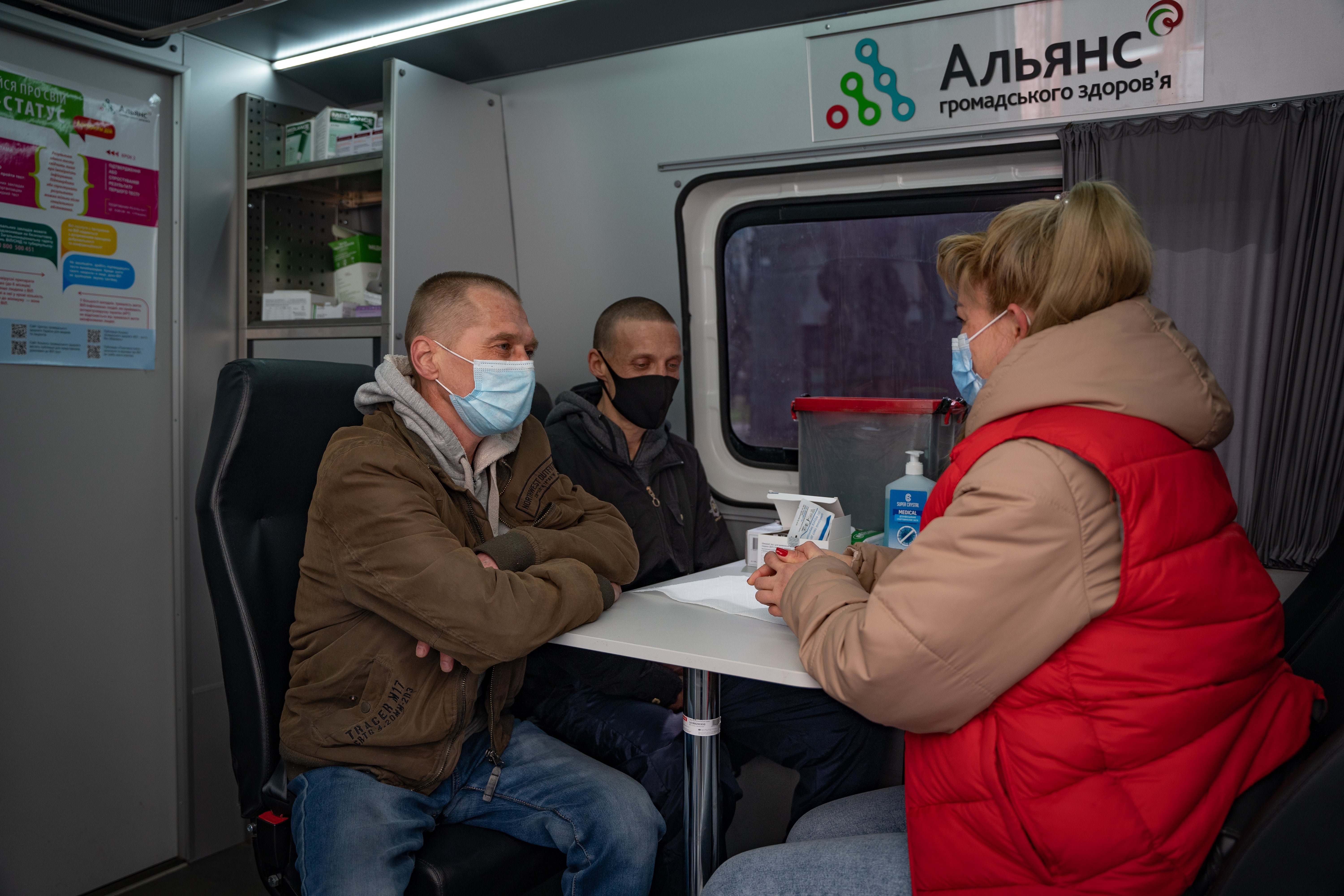 Liudmyla, a social worker, sits in one of APH’s mobile clinics in Odesa with her two clients, who both need treatment for HIV