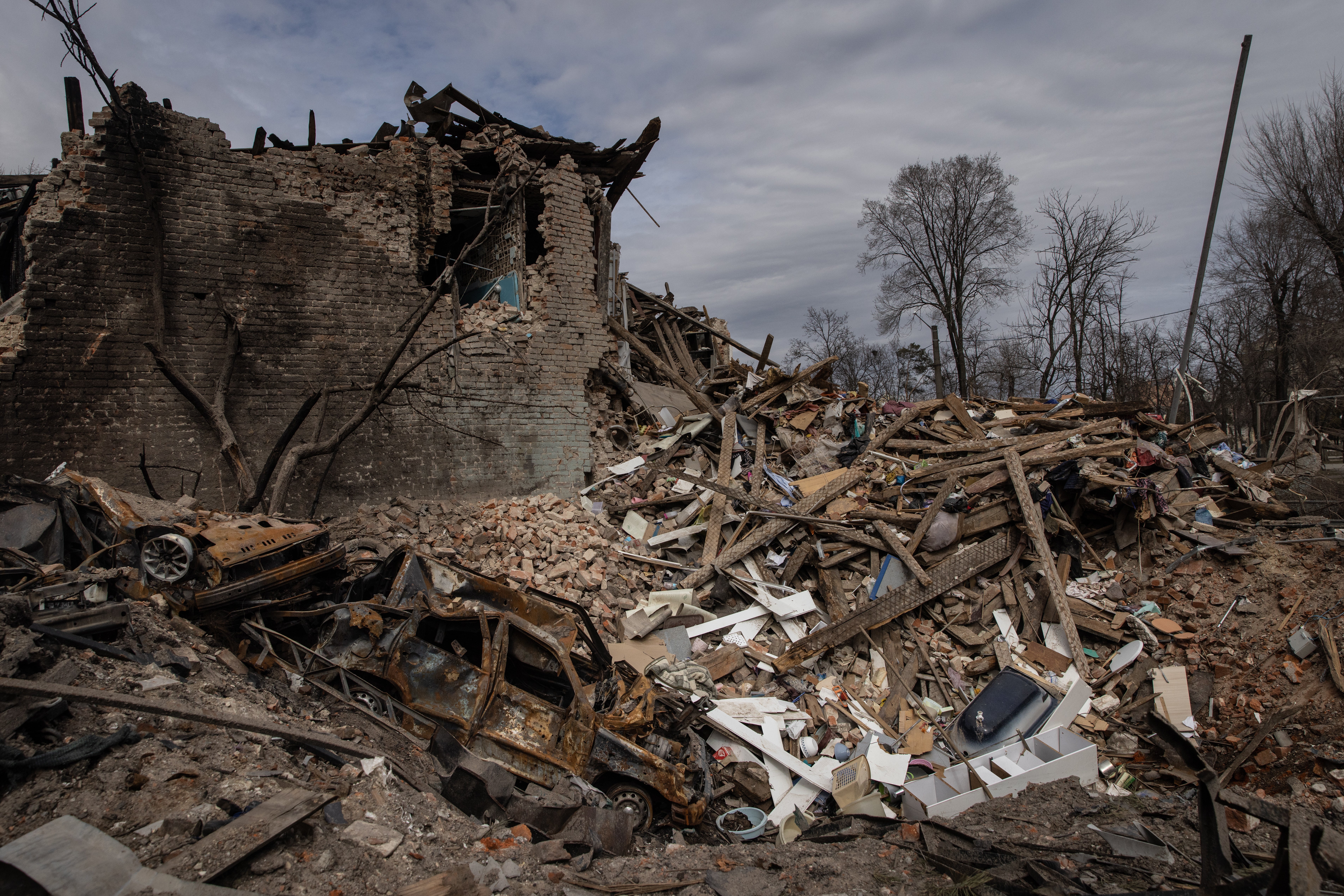 A destroyed car is seen in a crater following a Russian attack that destroyed a house in Kharkiv