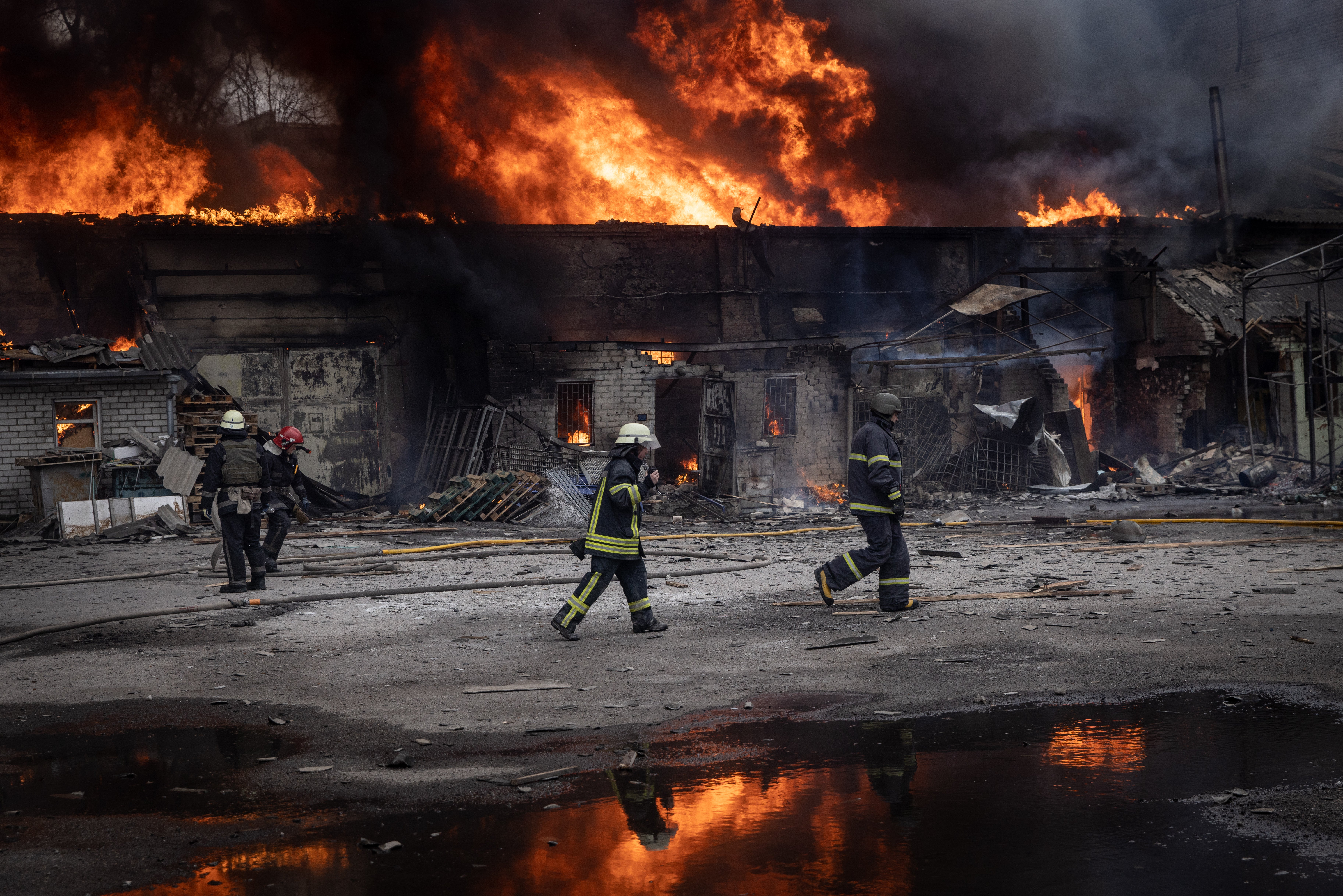 Firefighters work to extinguish a fire at a warehouse after it was hit by Russian shelling in Kharkiv