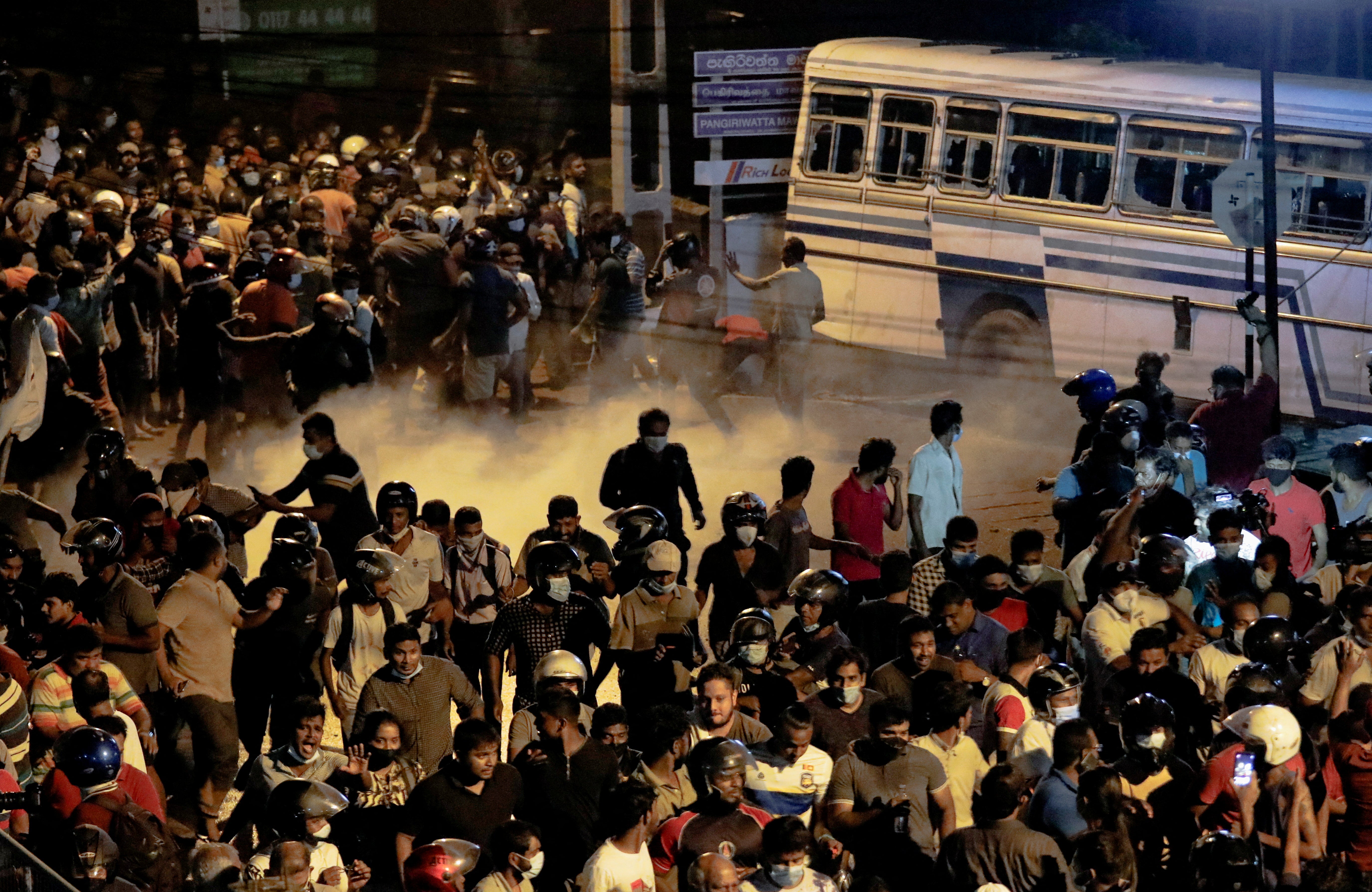 Demonstrators move away from tear gas used by the police near Sri Lankan President Gotabaya Rajapaksa's residence