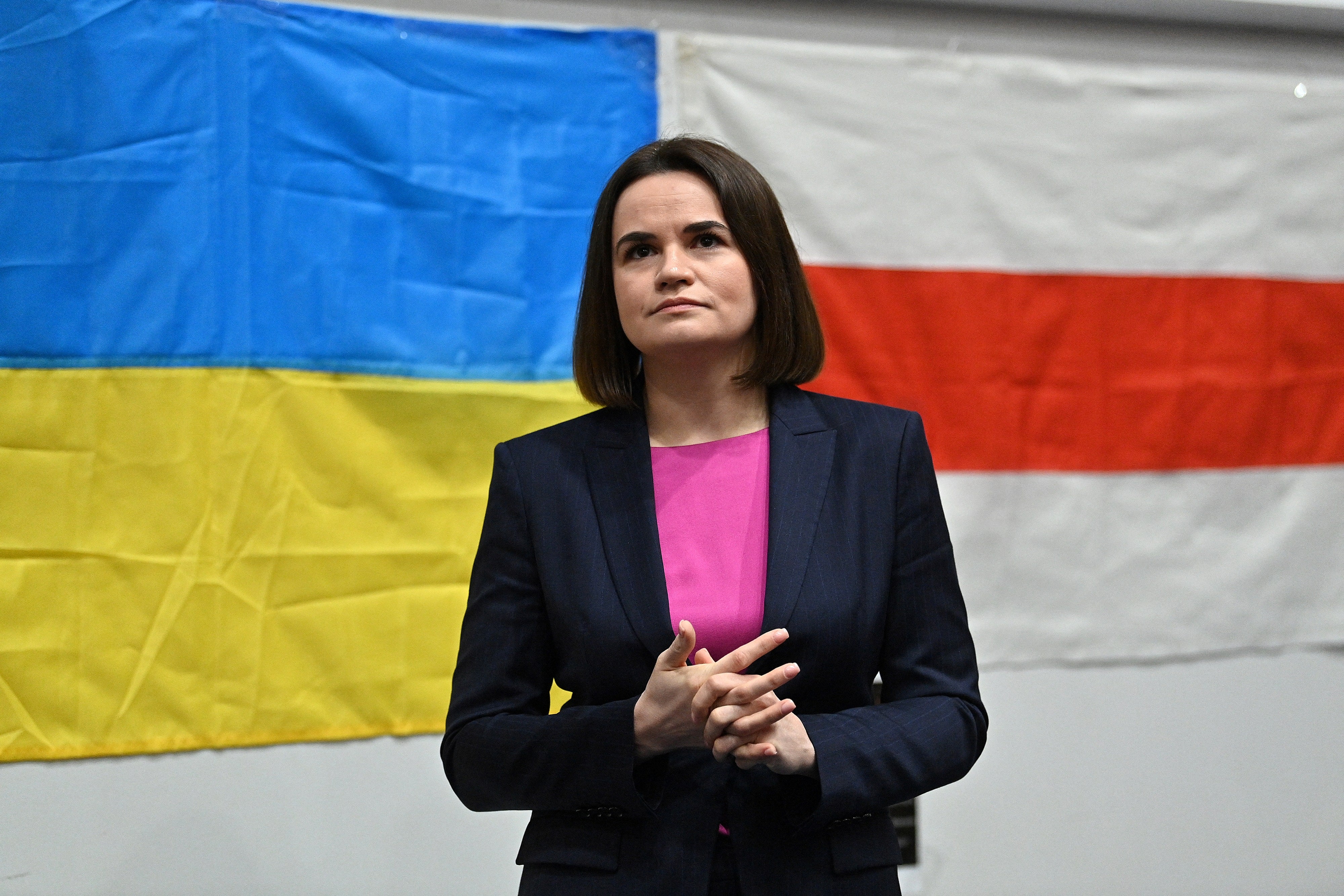 Belarus’s opposition leader Sviatlana Tsikhanouskaya stands in front of the national flag of Ukraine and the former national red and white flag of Belarus before addressing Belarusian diaspora in London, 9 March 2022