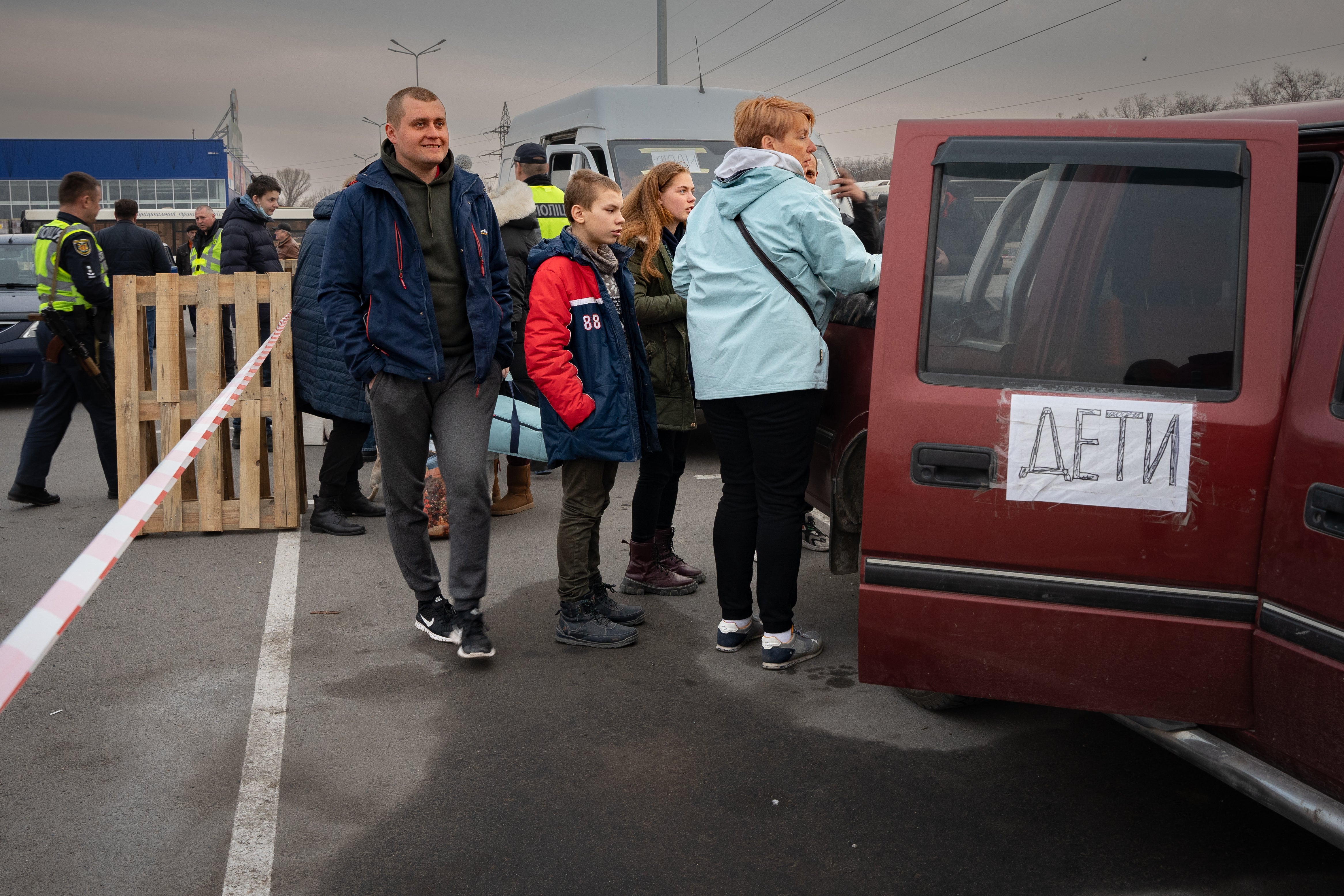 ‘Children’ in Russian is written on the car which a family drove through bombing from Mariupol