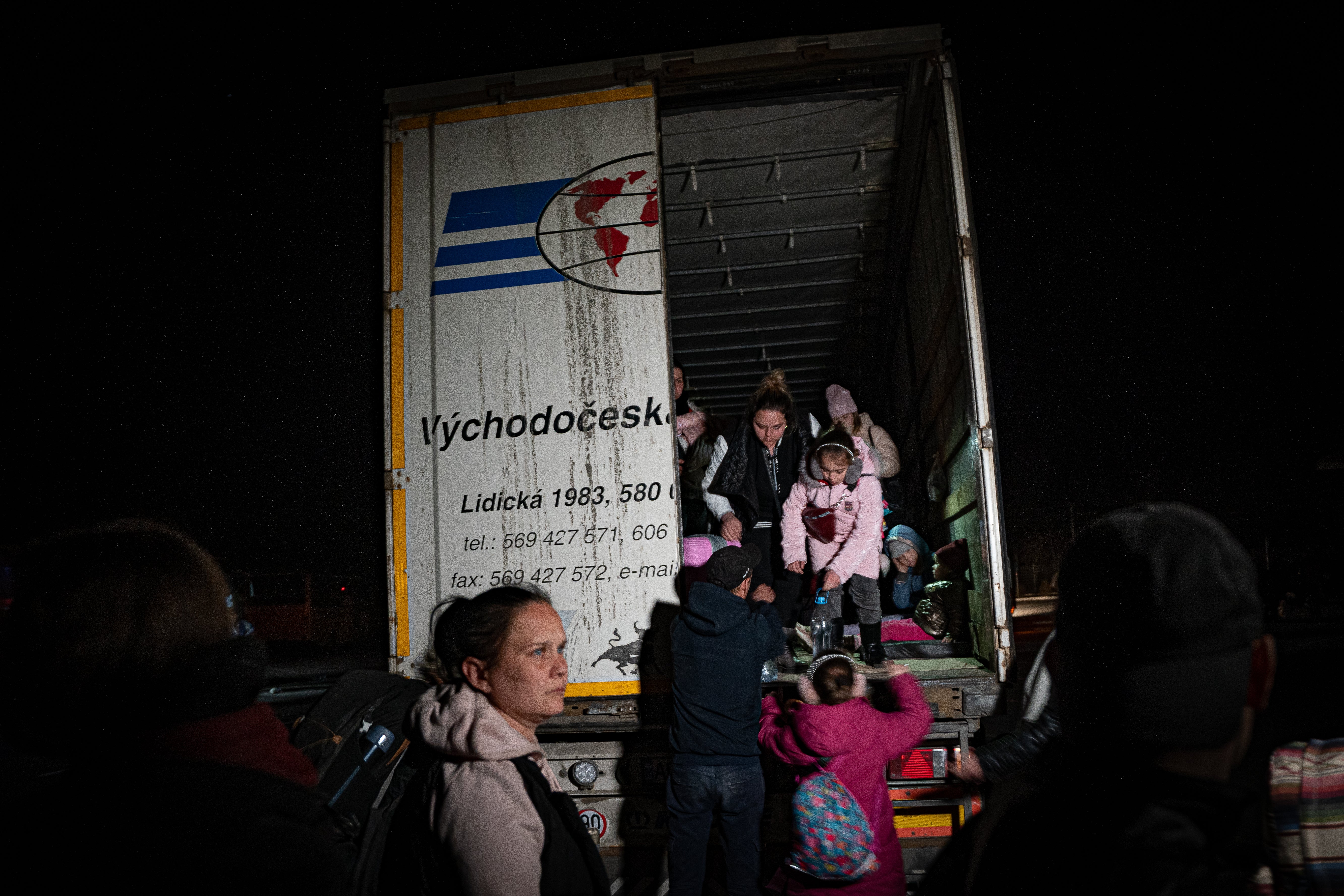 Children climb out of a truck holding over 50 people from occupied Melitopol that travelled 11 hours to safety