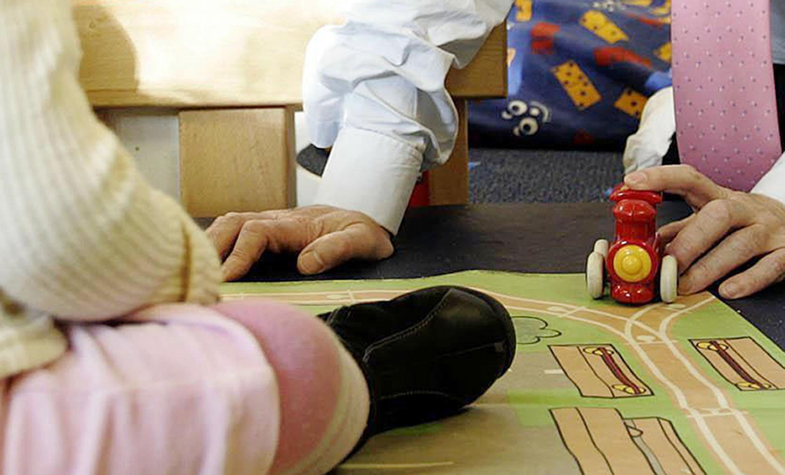 An adult playing with a child at a nursery (Edmond Terakopian/PA)