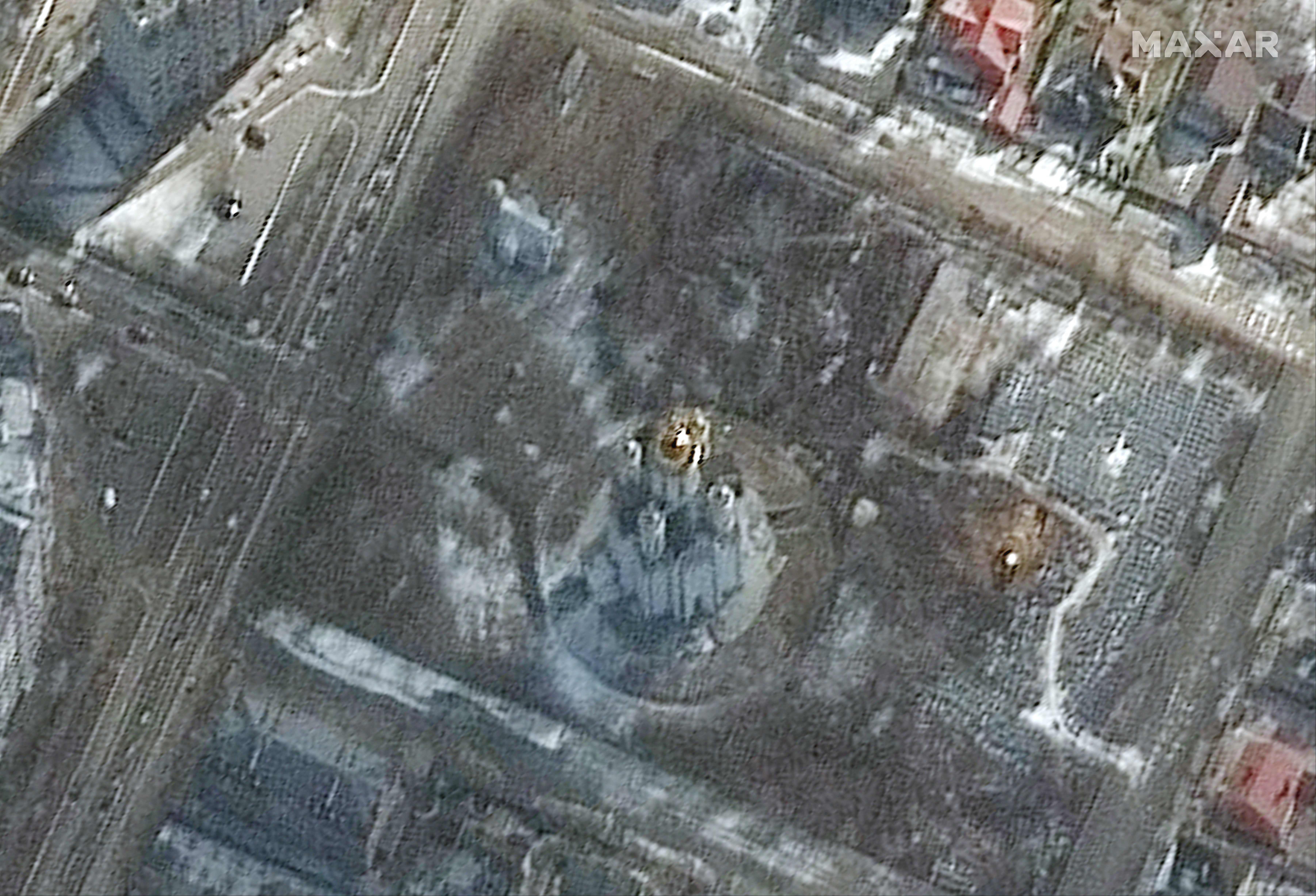 This handout satellite image released by Maxar Technologies on April 3, 2022 shows probable excavation of earth at a grave site (R) near the Church of Saint Andrew and Pyervozvannoho All Saints in Bucha, Ukraine, on March 10, 2022.