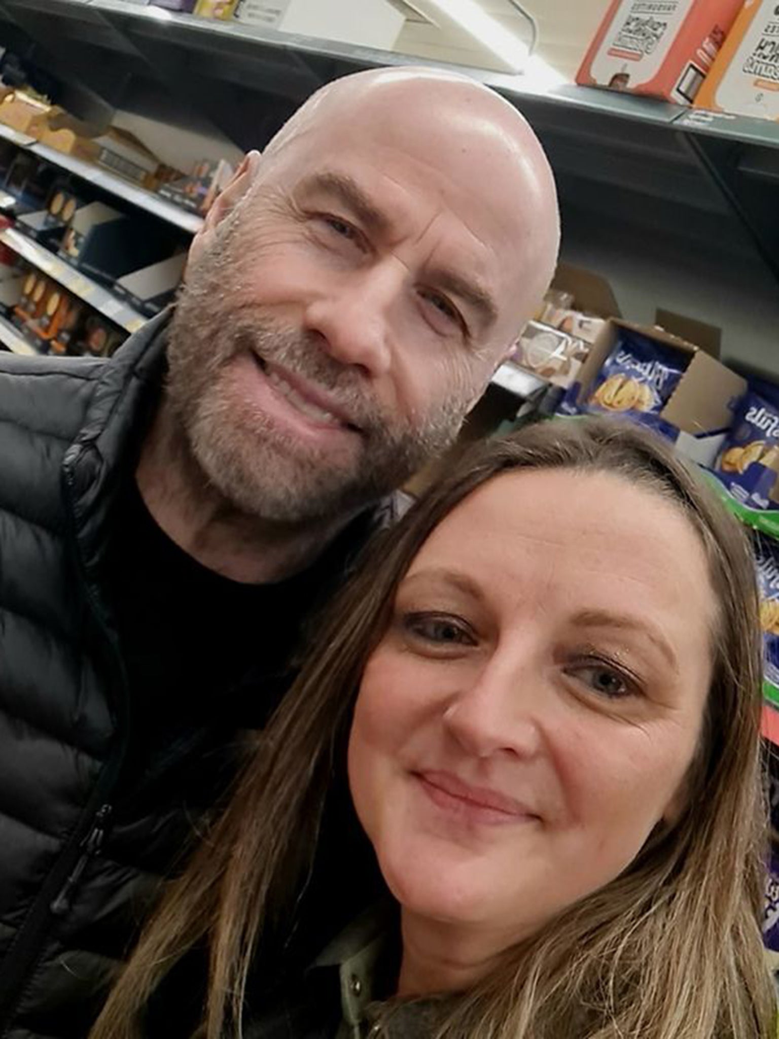 Travolta posed with staff members including Nicola Gee