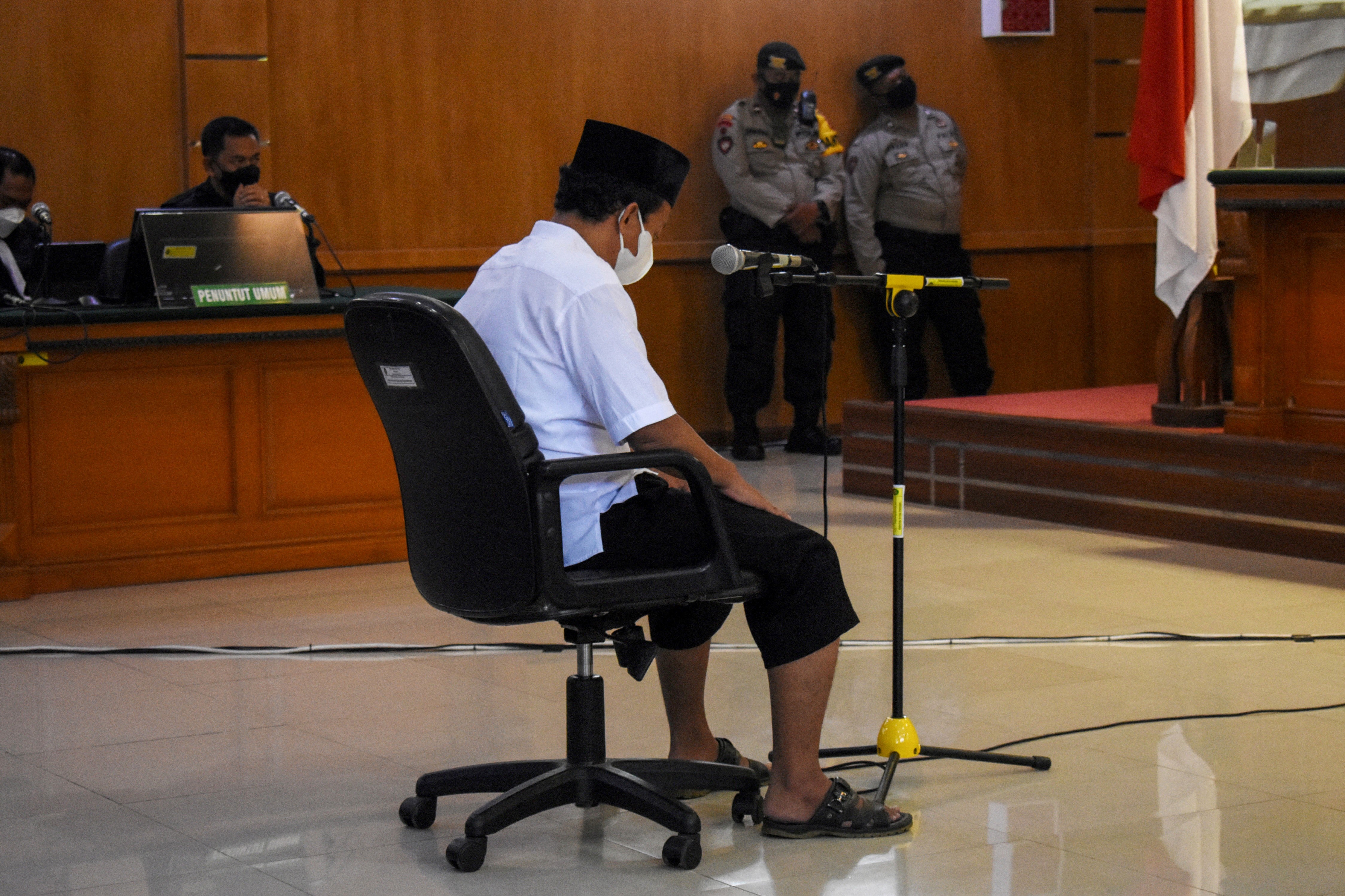 Herry Wirawan sits during his trial at a court in Bandung, West Java