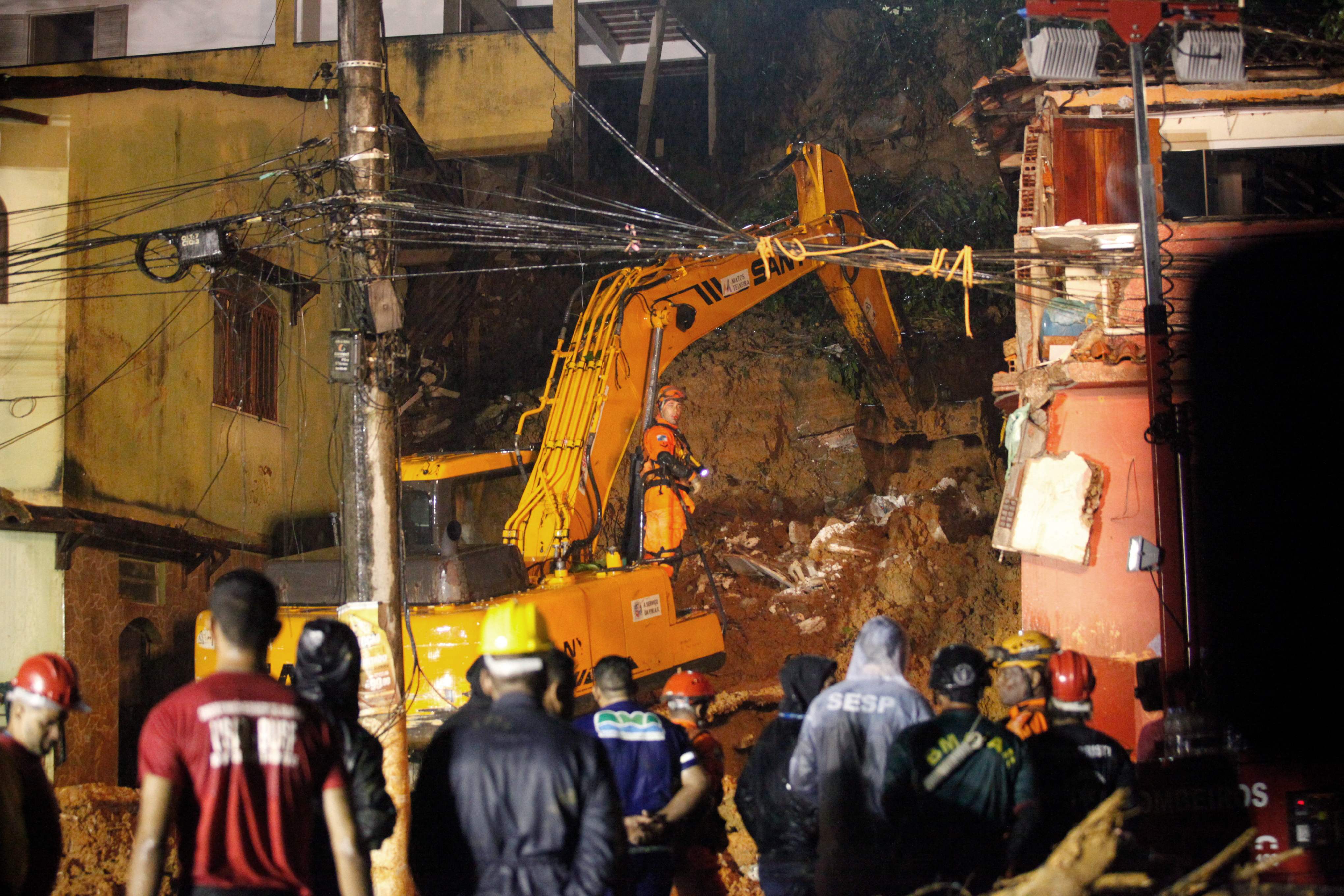 Rescue workers at the site of a landslide where a mother and six of her children died in southeastern Brazil. A seventh child was rescued