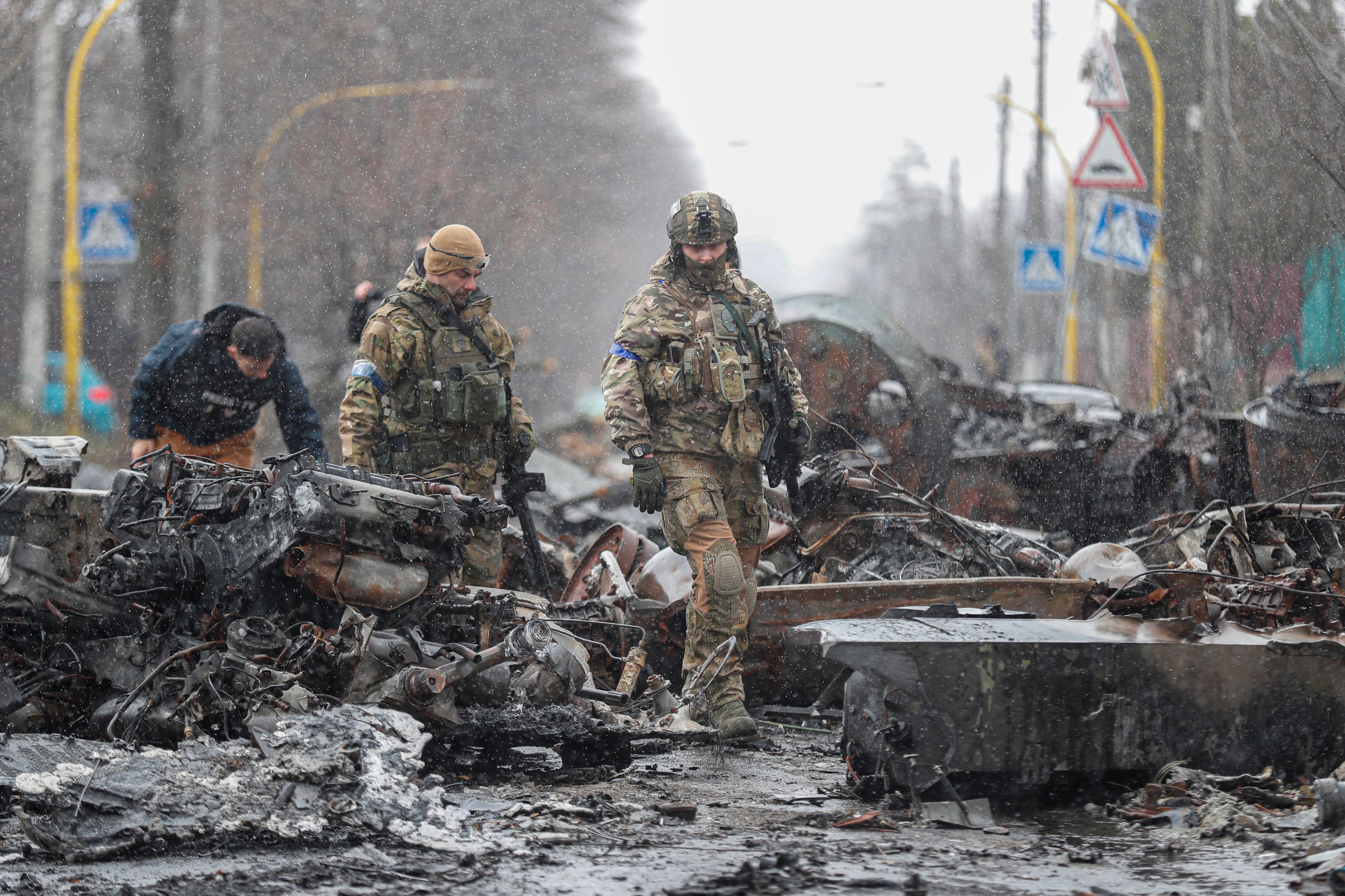 Ukrainian Soldiers inspect destroyed Russian military machinery in the city of Bucha