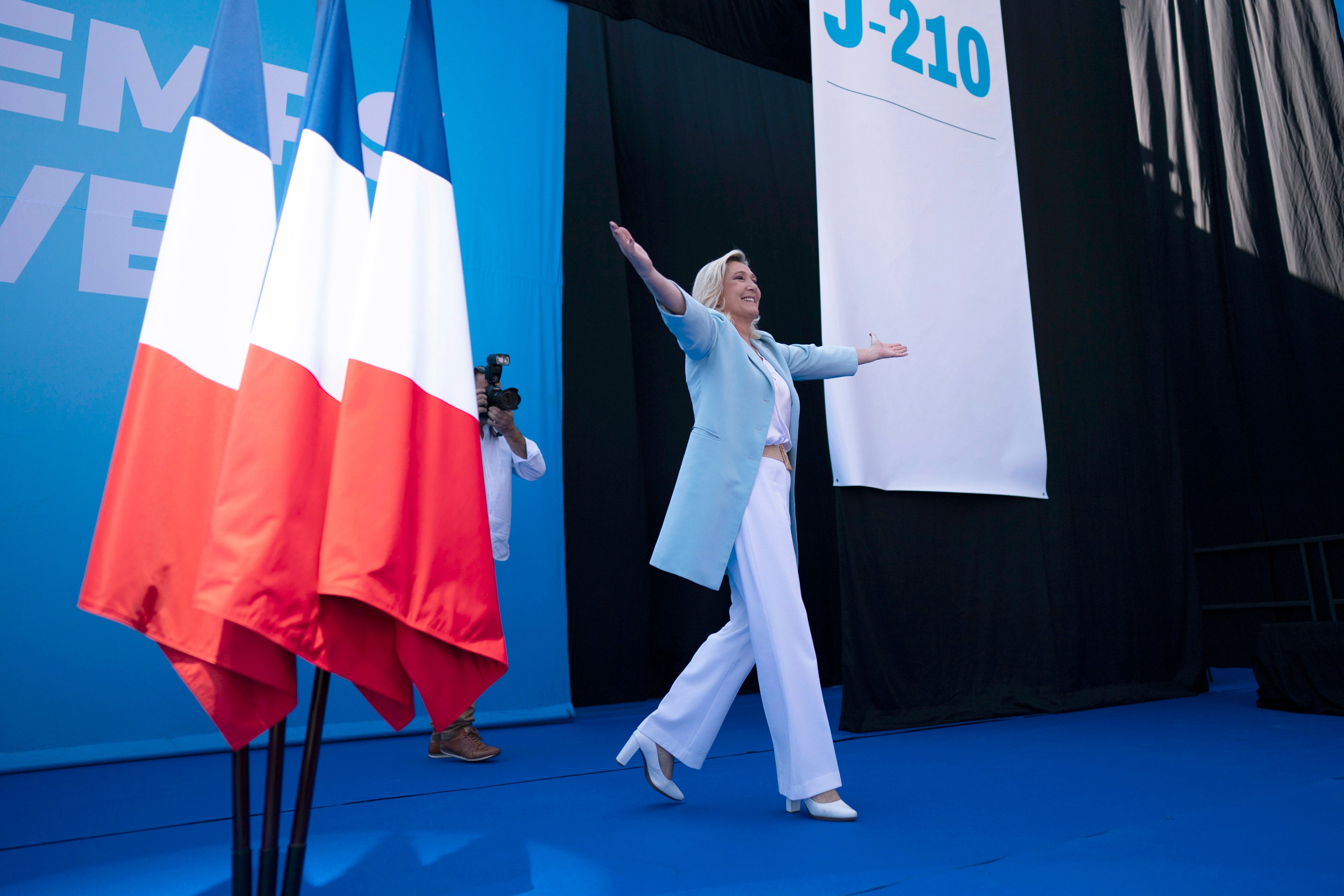 Marine Le Pen walks on stage, at a National Rally event in Frejus