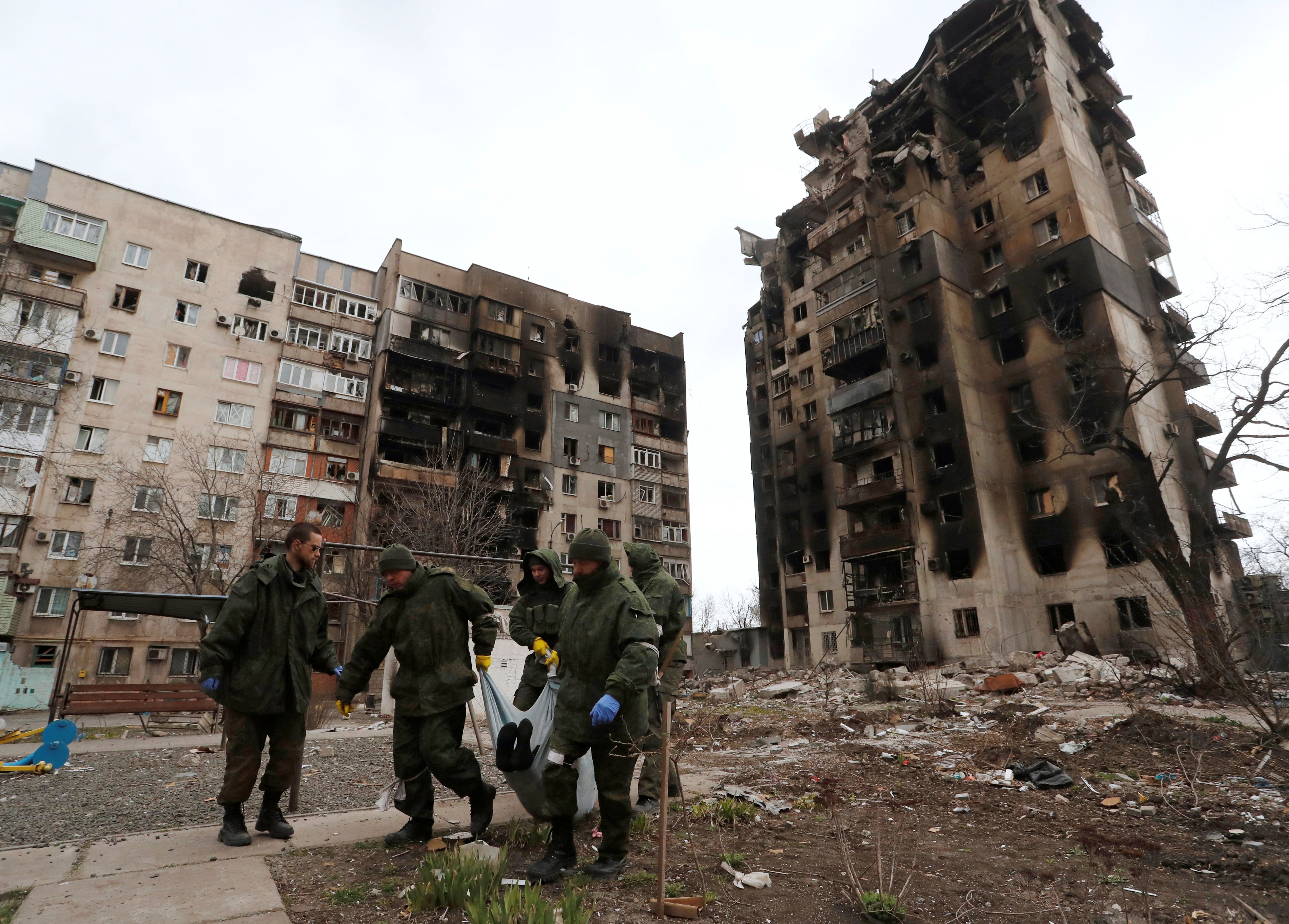 Service members of pro-Russian troops collect bodies of the dead to take them to the morgue in Mariupol