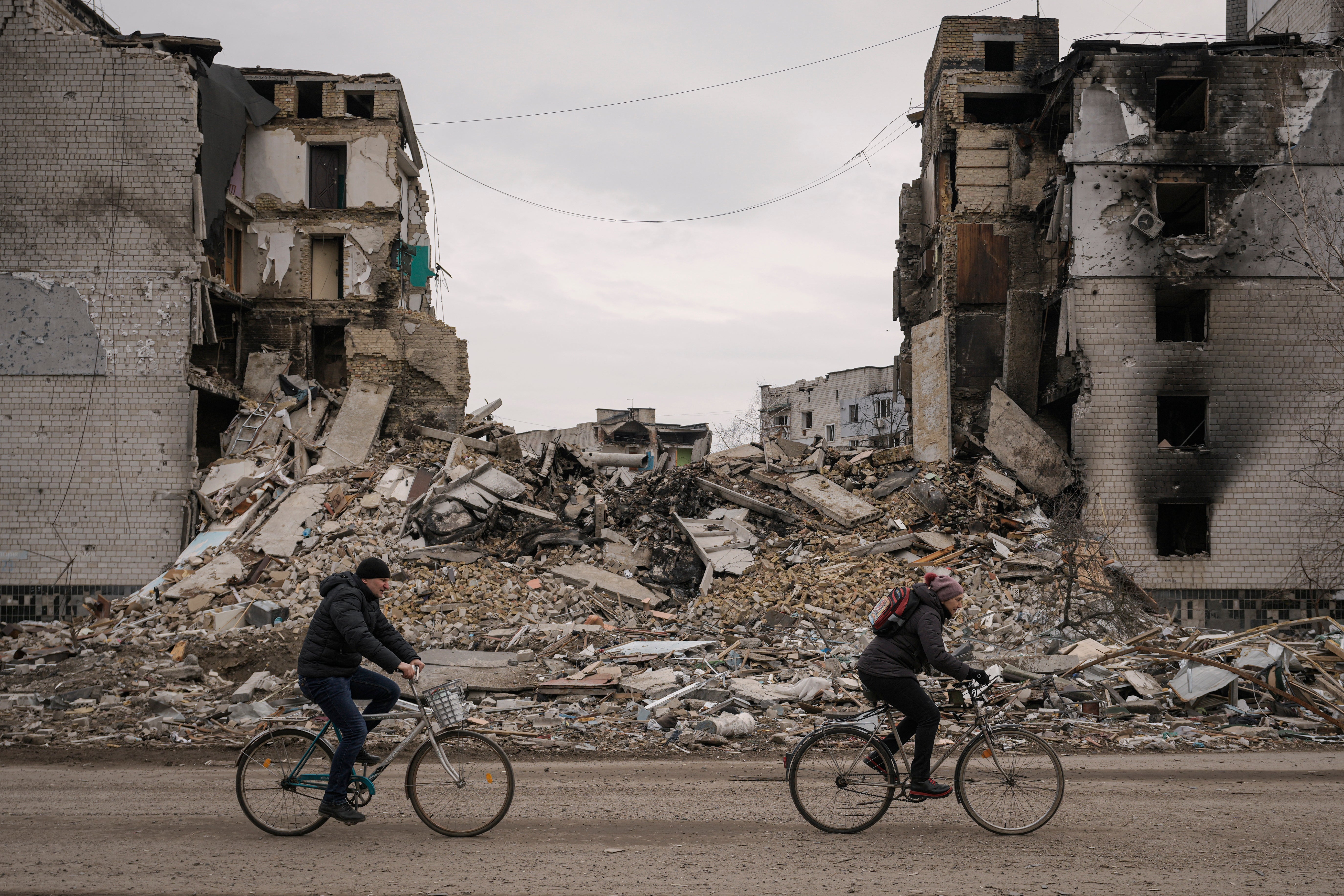 Cyclists pass scenes of destruction in Borodyanka, Ukraine, on 5 April 2022