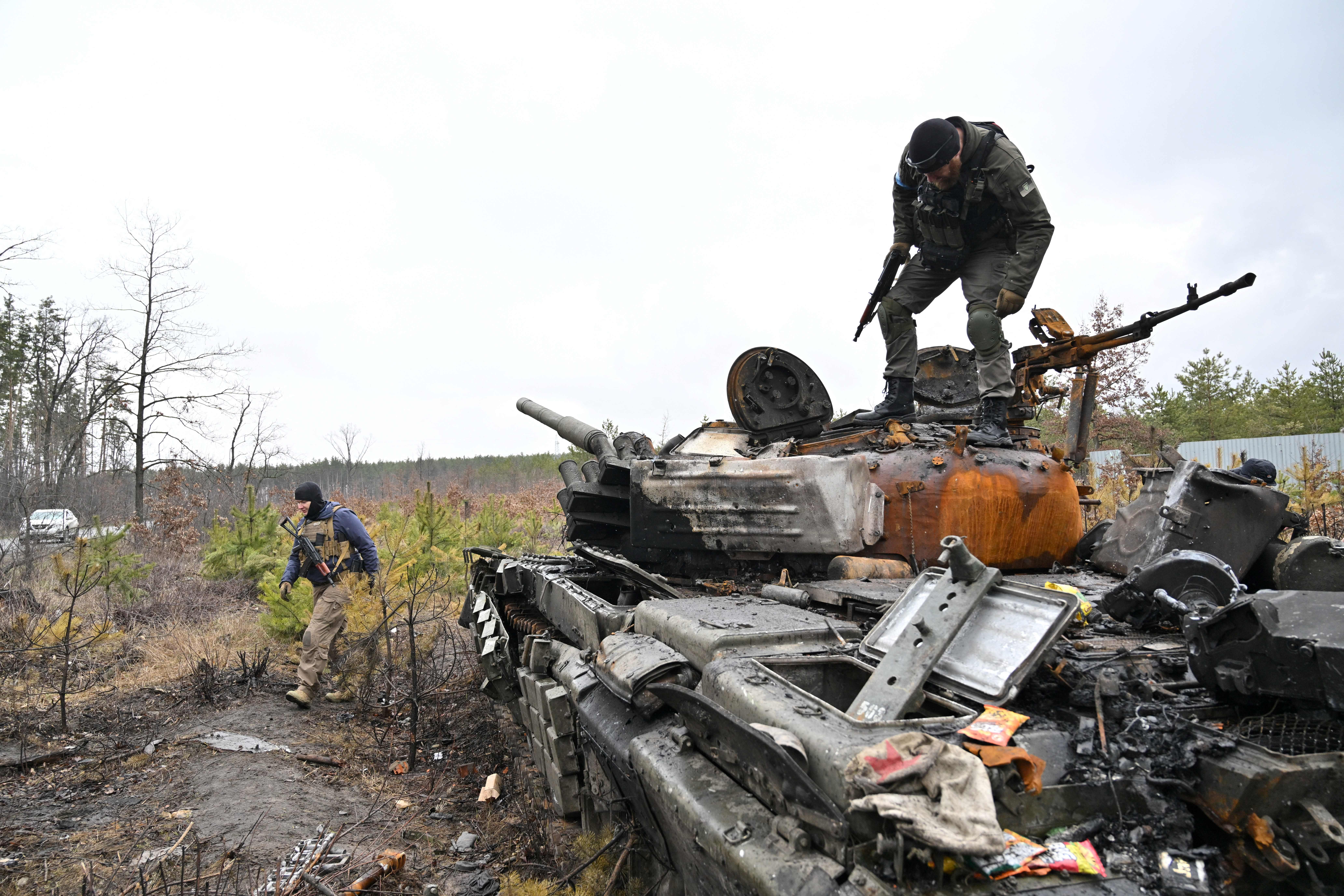 A Ukrainian serviceman stands on a destroyed Russian army tank not far from the Ukrainian capital of Kyiv on 3 April