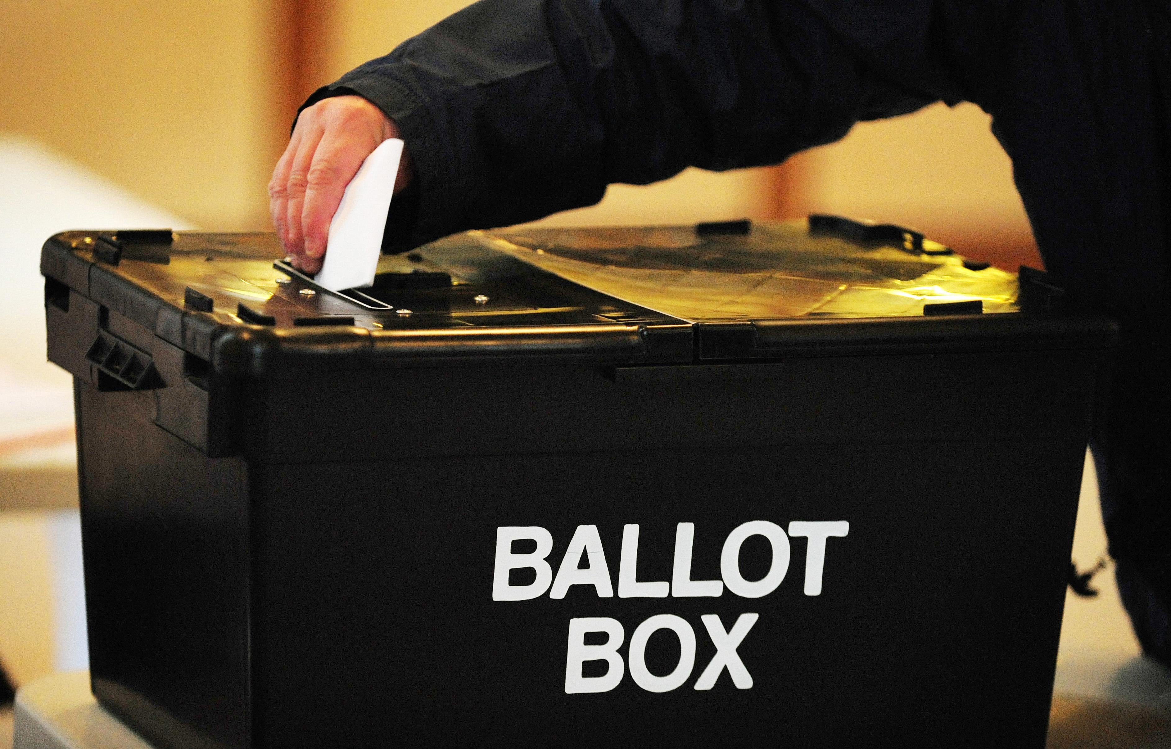 A voter puts a ballot paper in a ballot box at a polling station (Rui Vieira/PA)