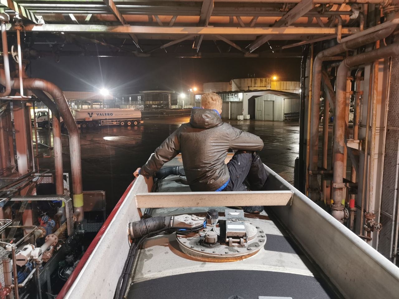 A protester sits atop a tanker at the Kingsbury Oil Terminal